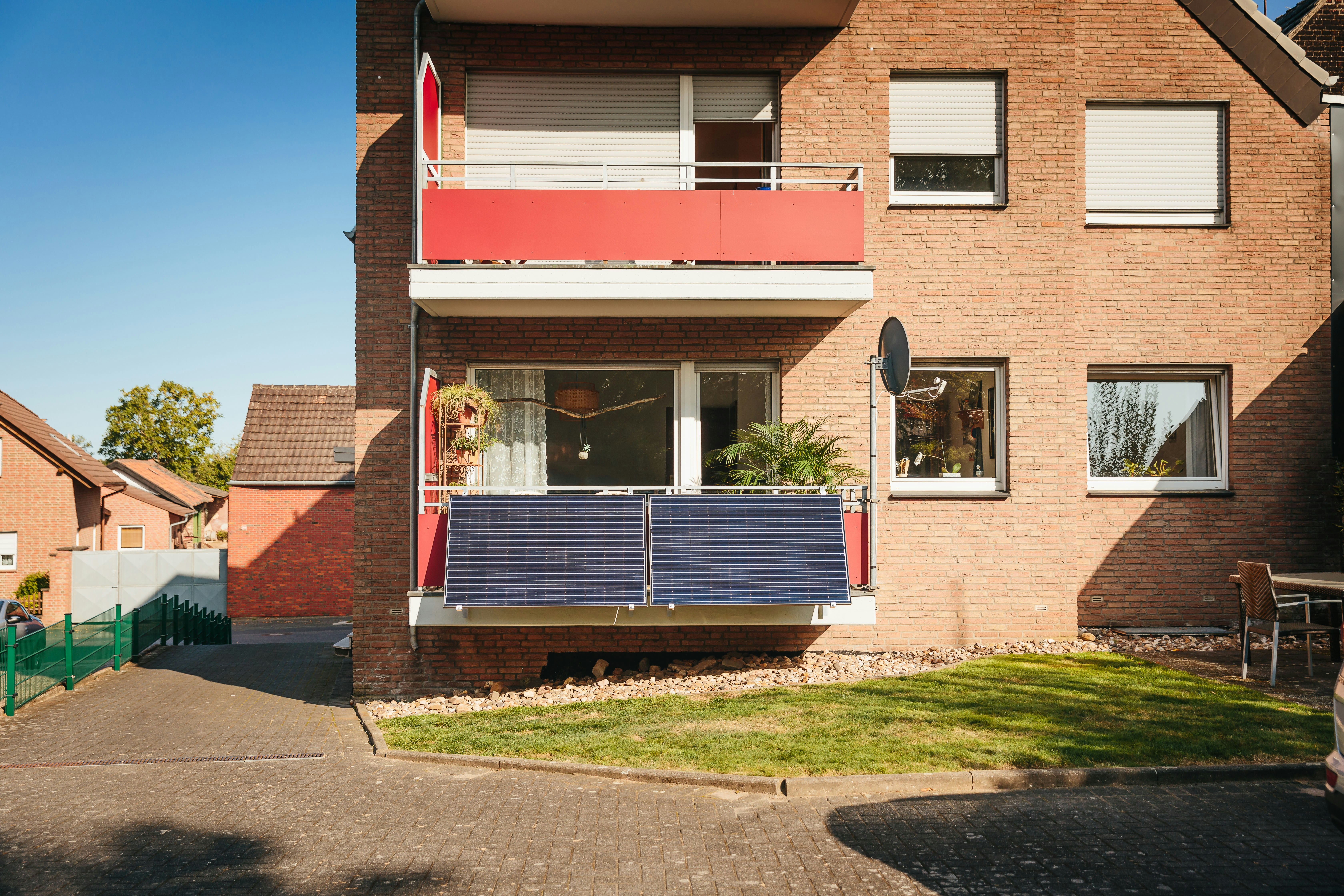 Balcony with solar panels on brick building