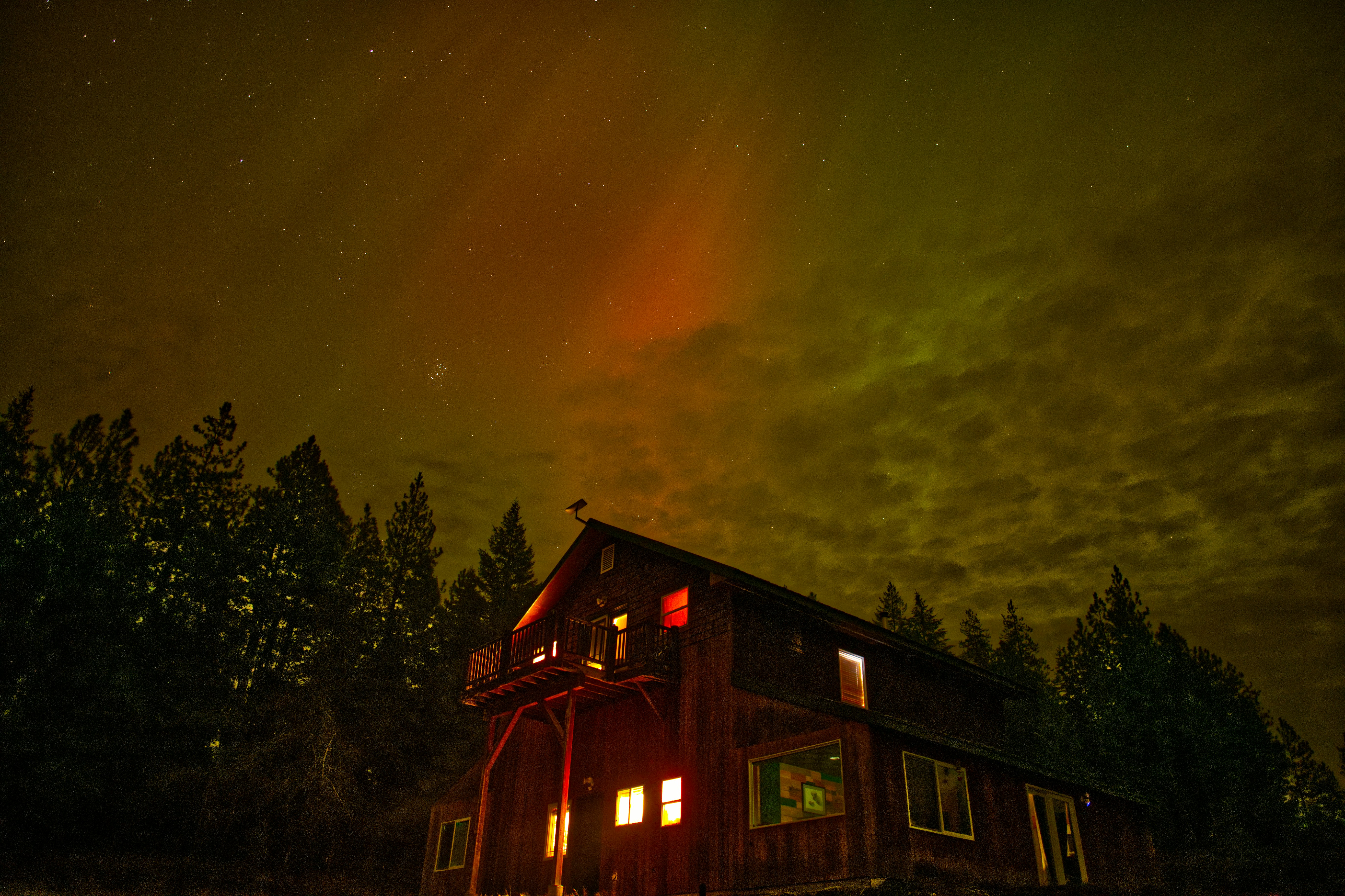 Wooden cabin under the aurora borealis at night
