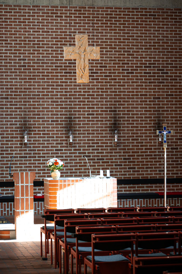 Wooden cross above a bright sanctuary altar