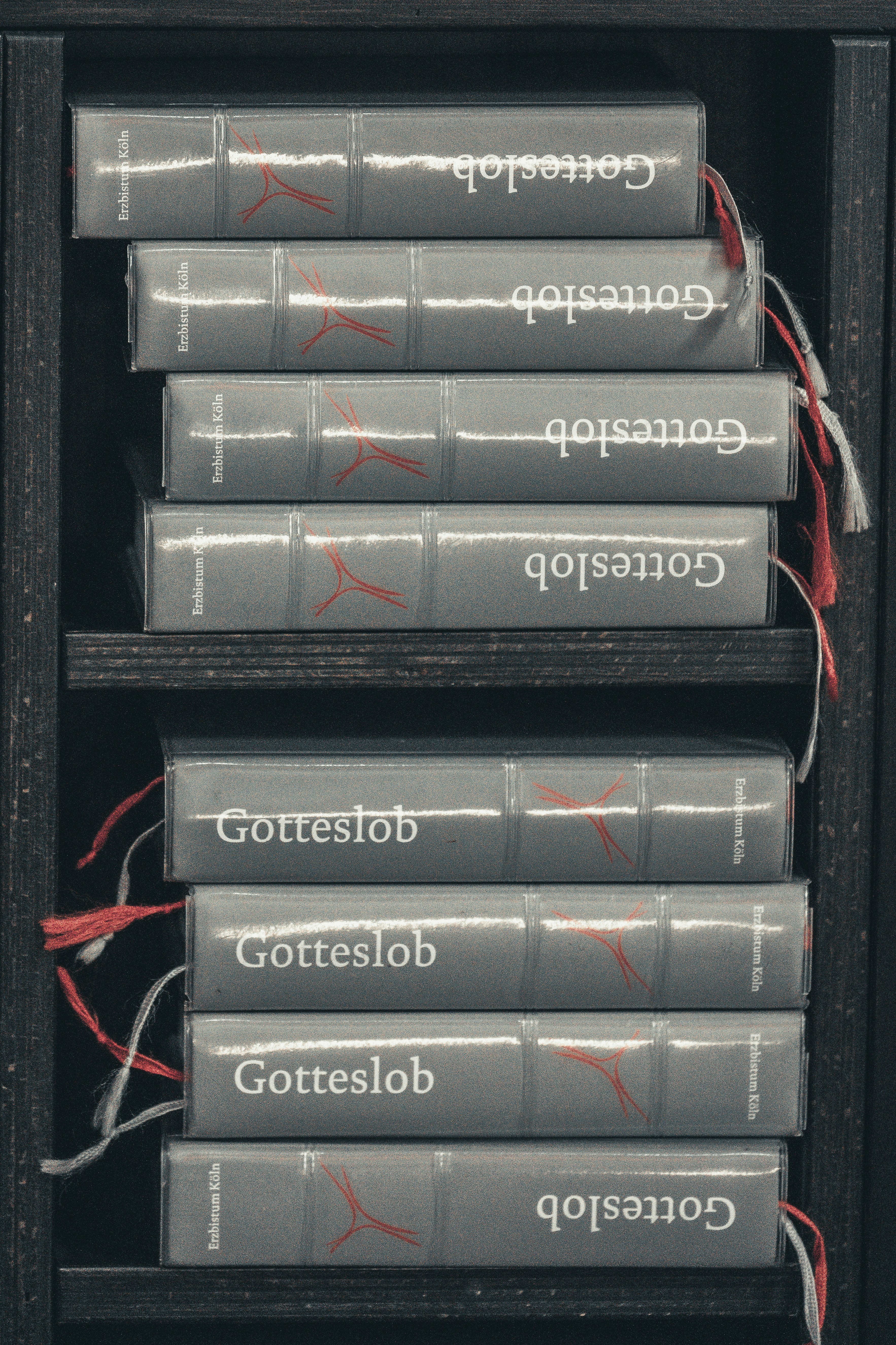 Stack of gray books with 'gotteslob' on spines.