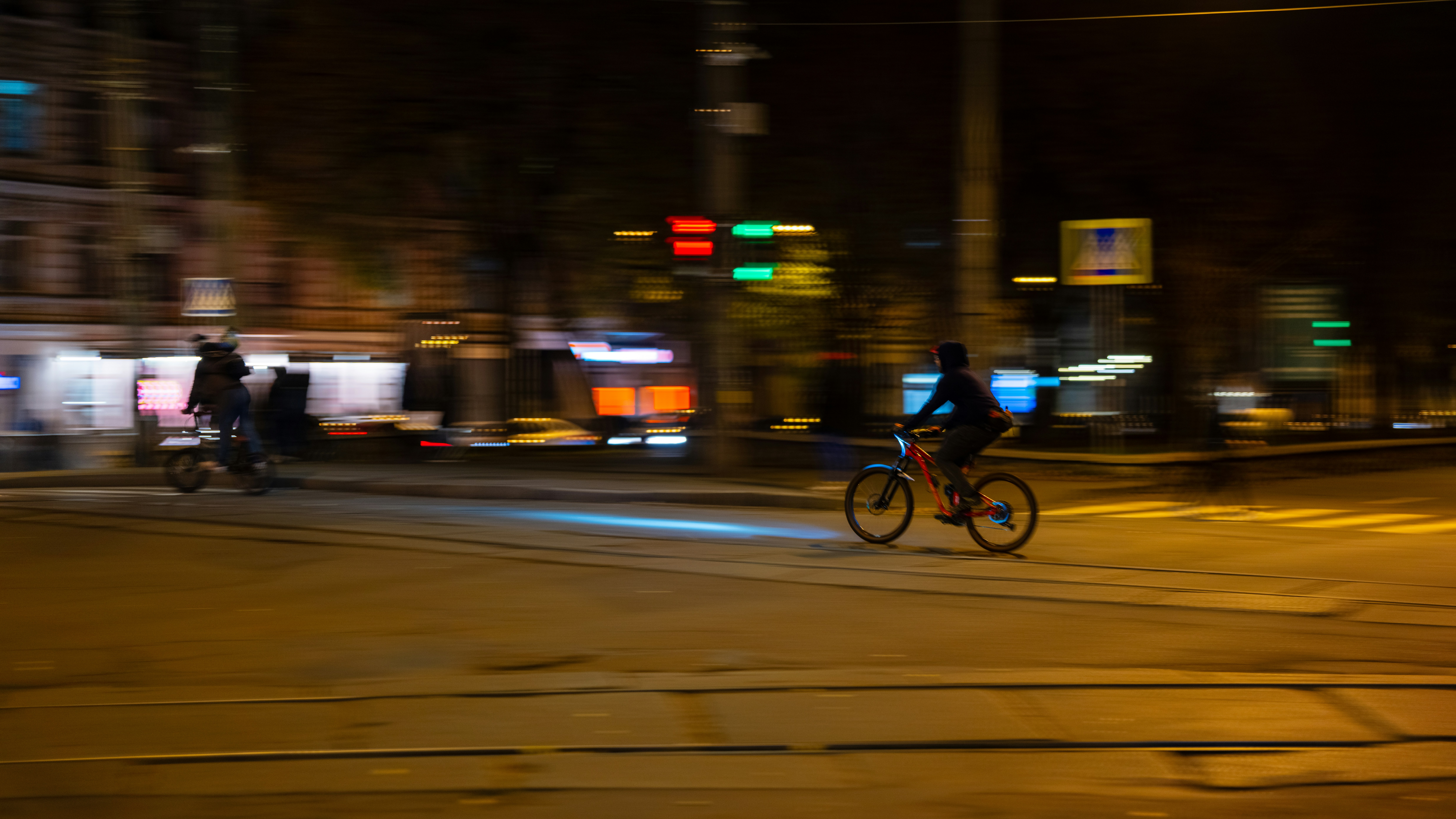 Person riding bicycle on city street at night