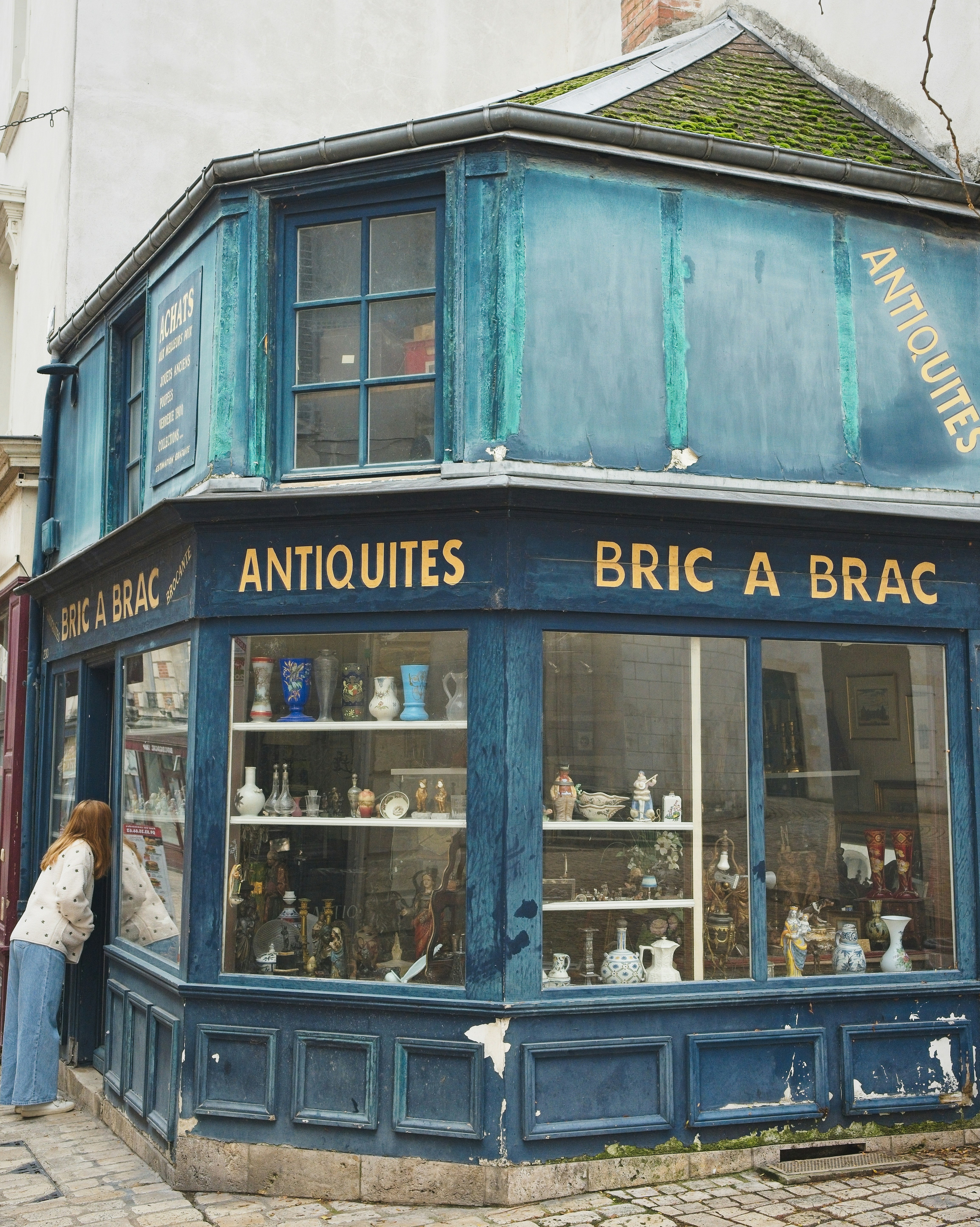 Woman looking into an antique shop window