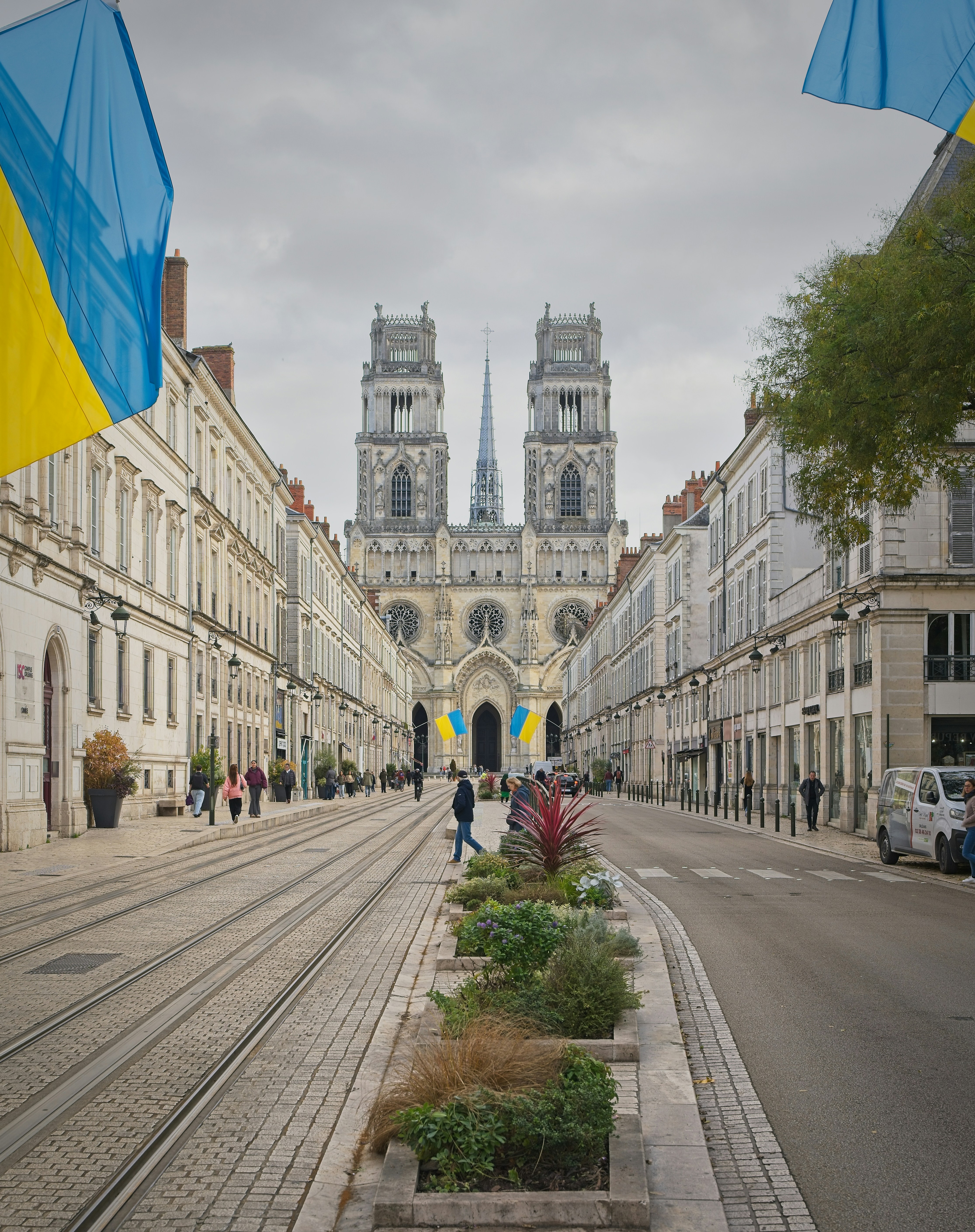 Cathedral flanked by buildings on a street with trams