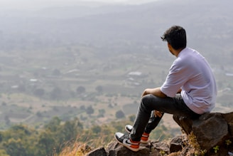 Man sitting on rocks overlooking a valley