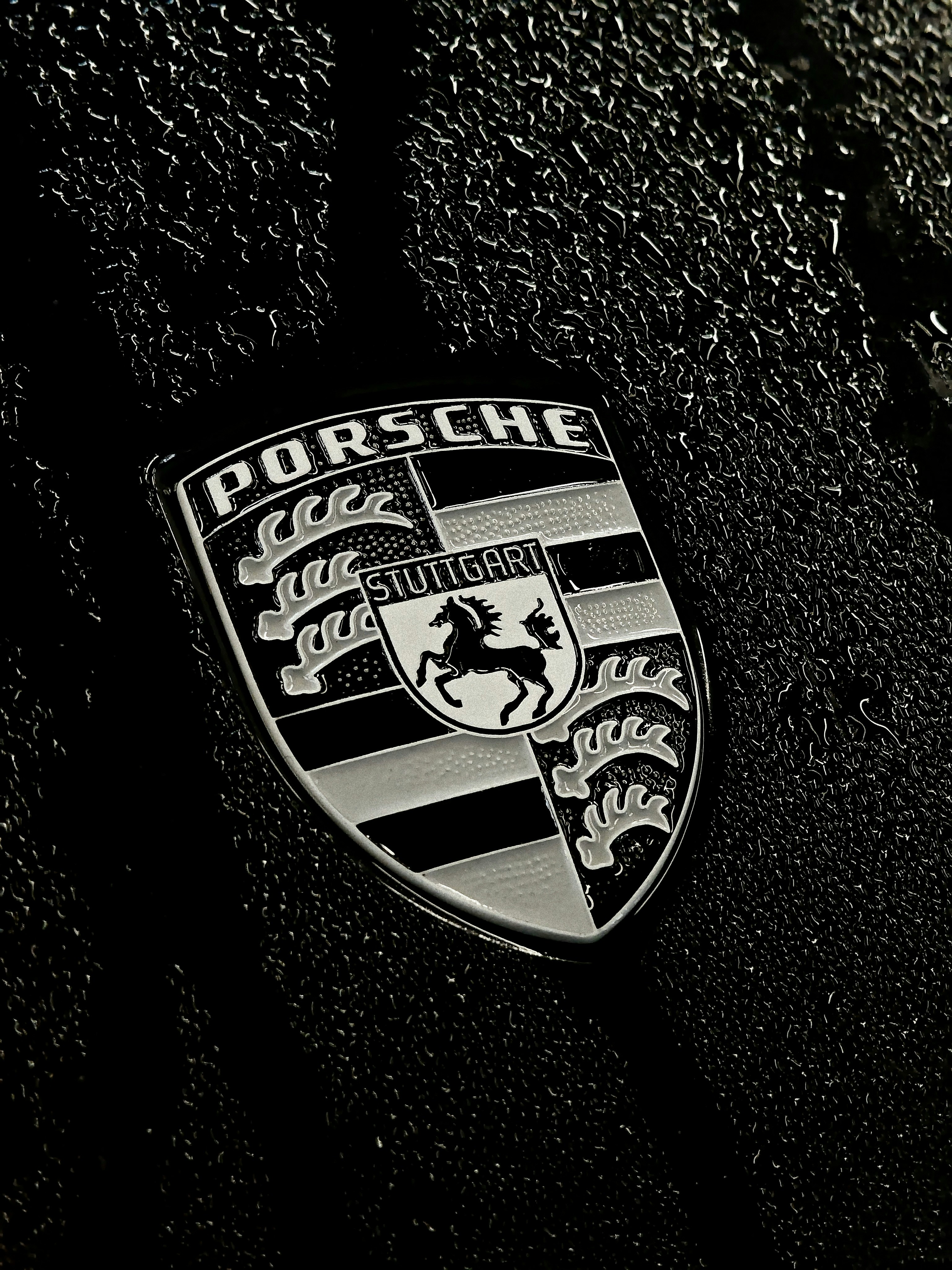 Porsche emblem on a textured dark surface
