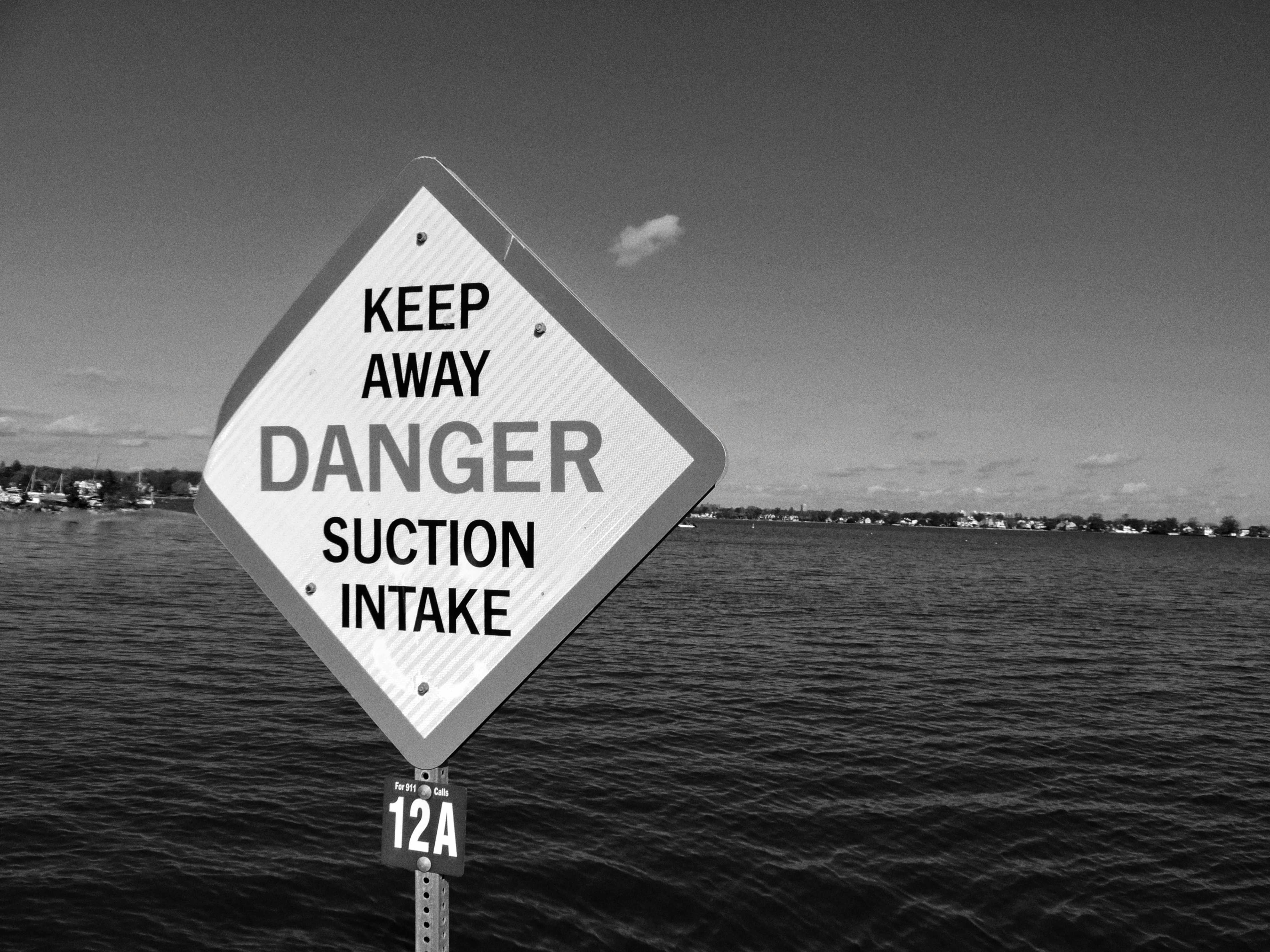 Danger suction intake warning sign near water