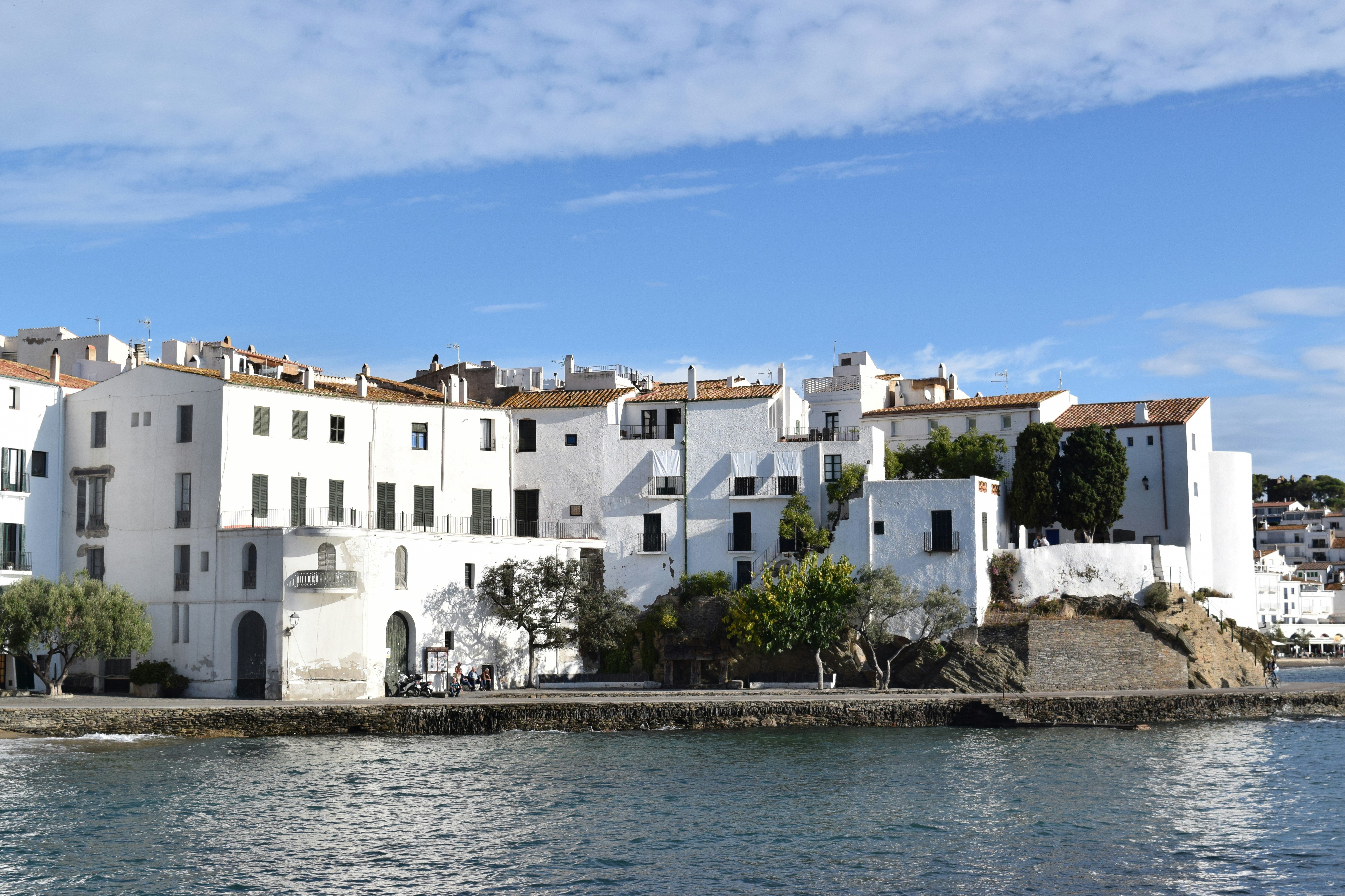 White buildings line the waterfront under a blue sky.