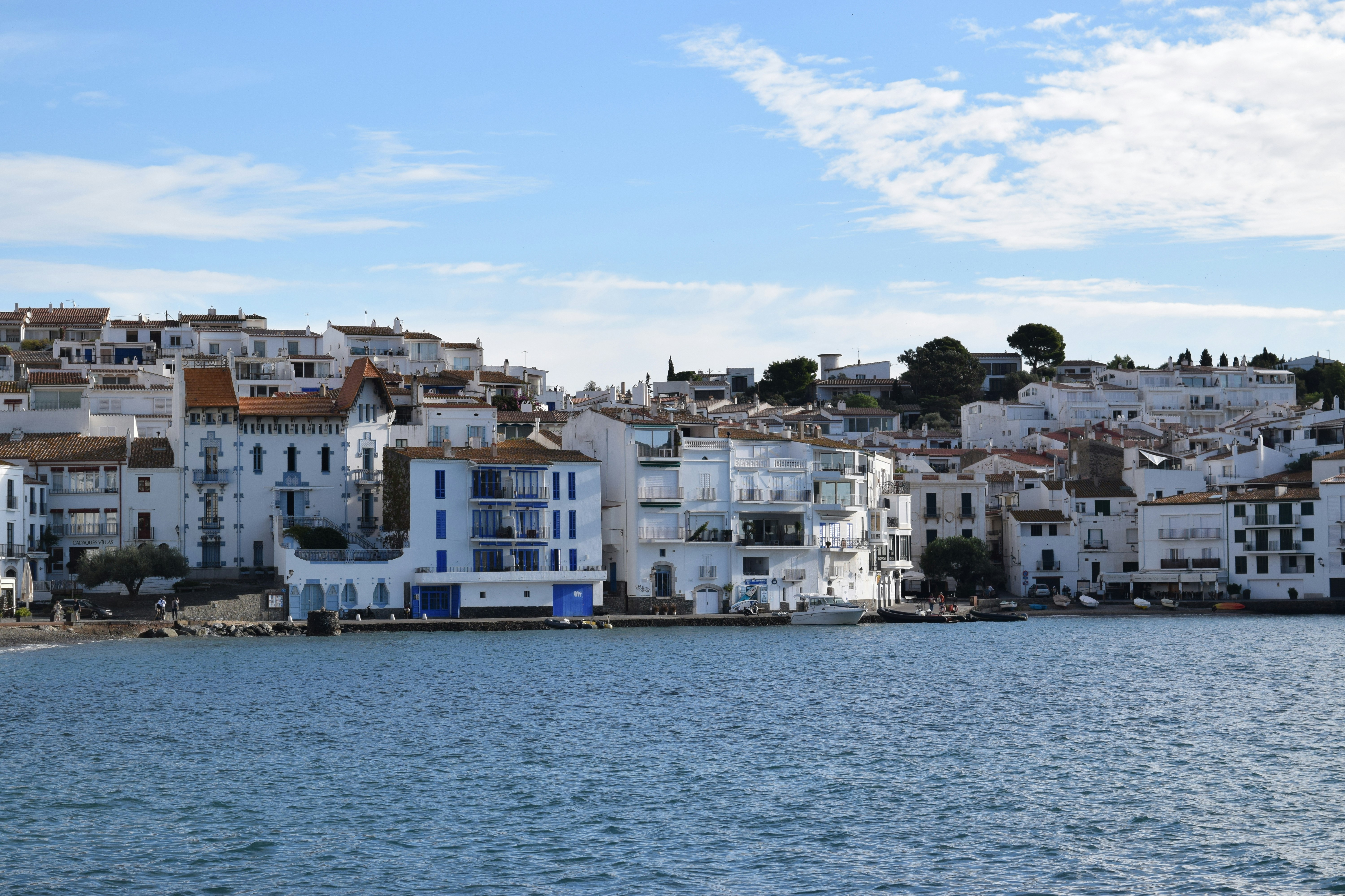 White buildings line the coast by the blue ocean.