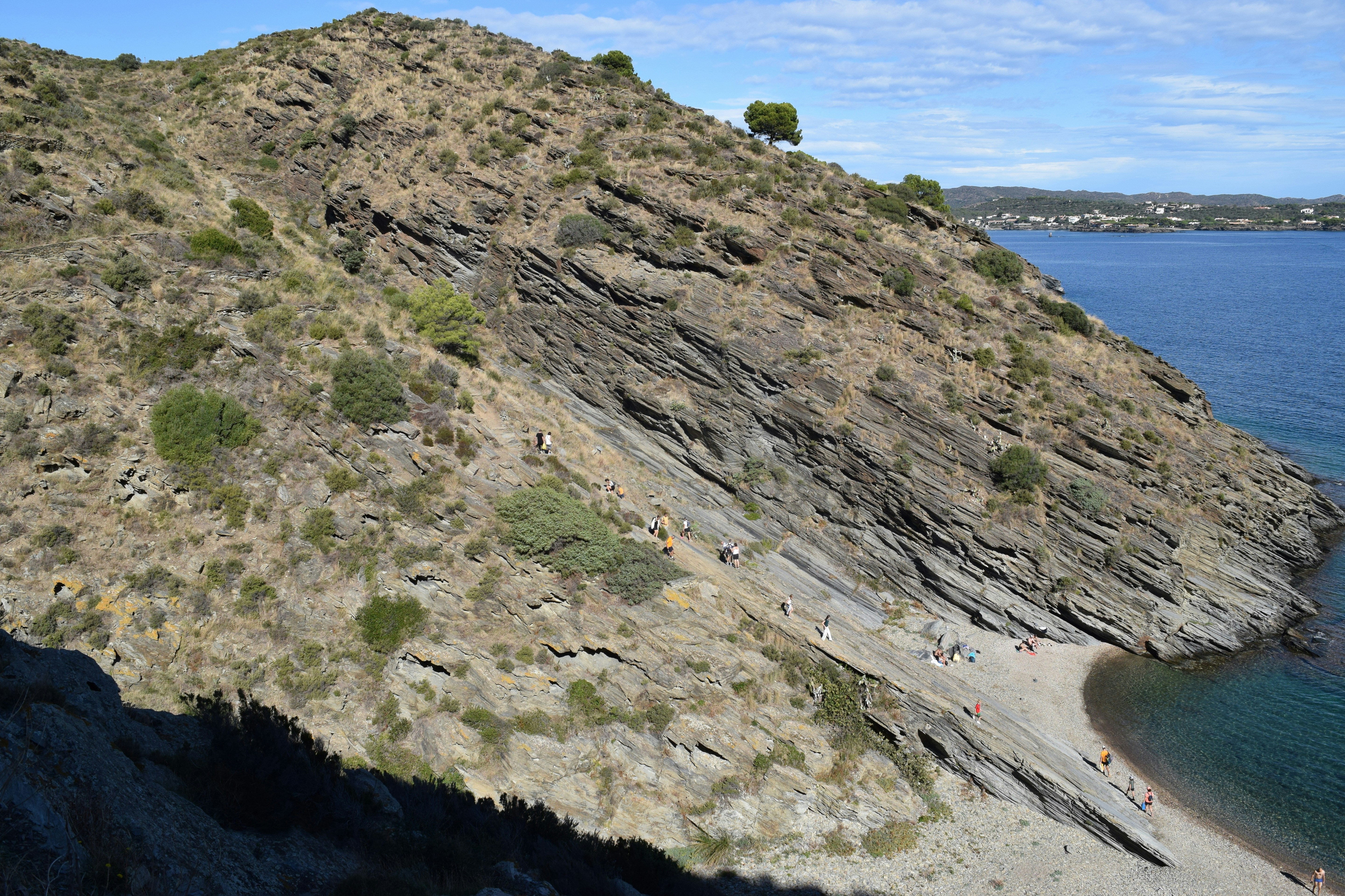 Rocky coastline with a small beach and blue water.