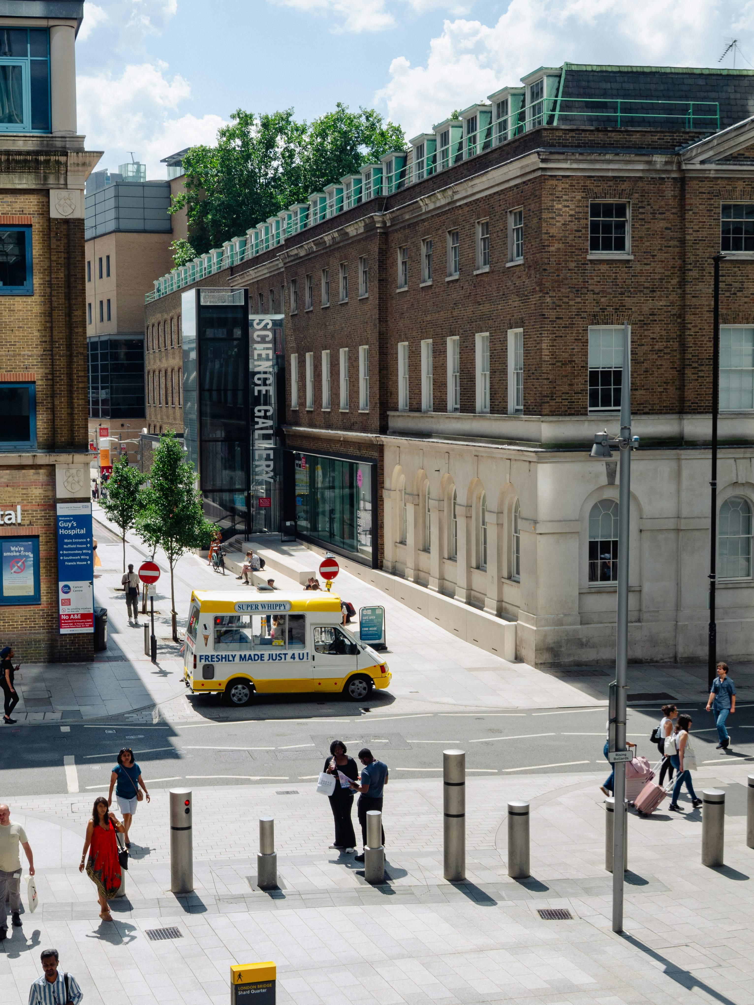 People walking on city street with ice cream truck.