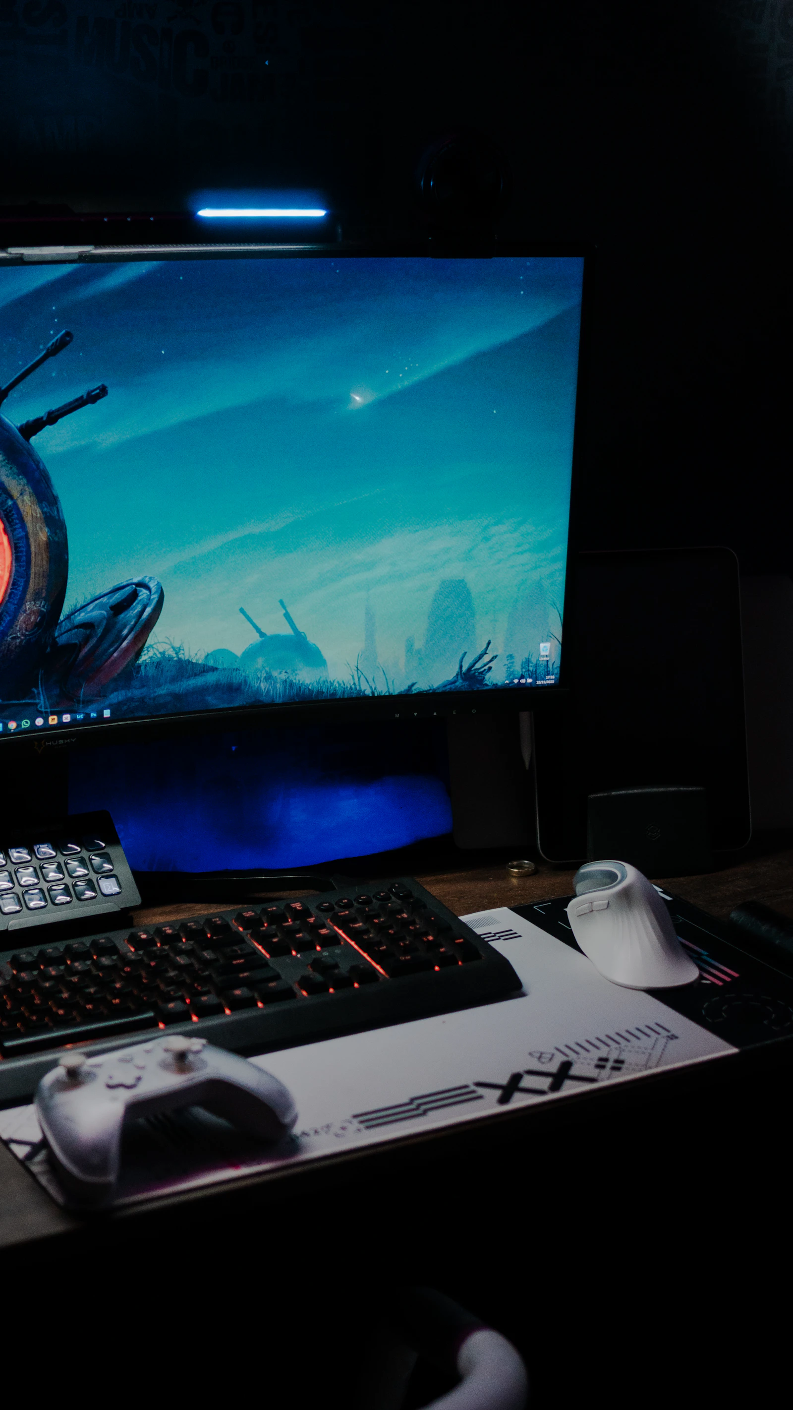 Gaming PC desk with glowing keyboard and controller