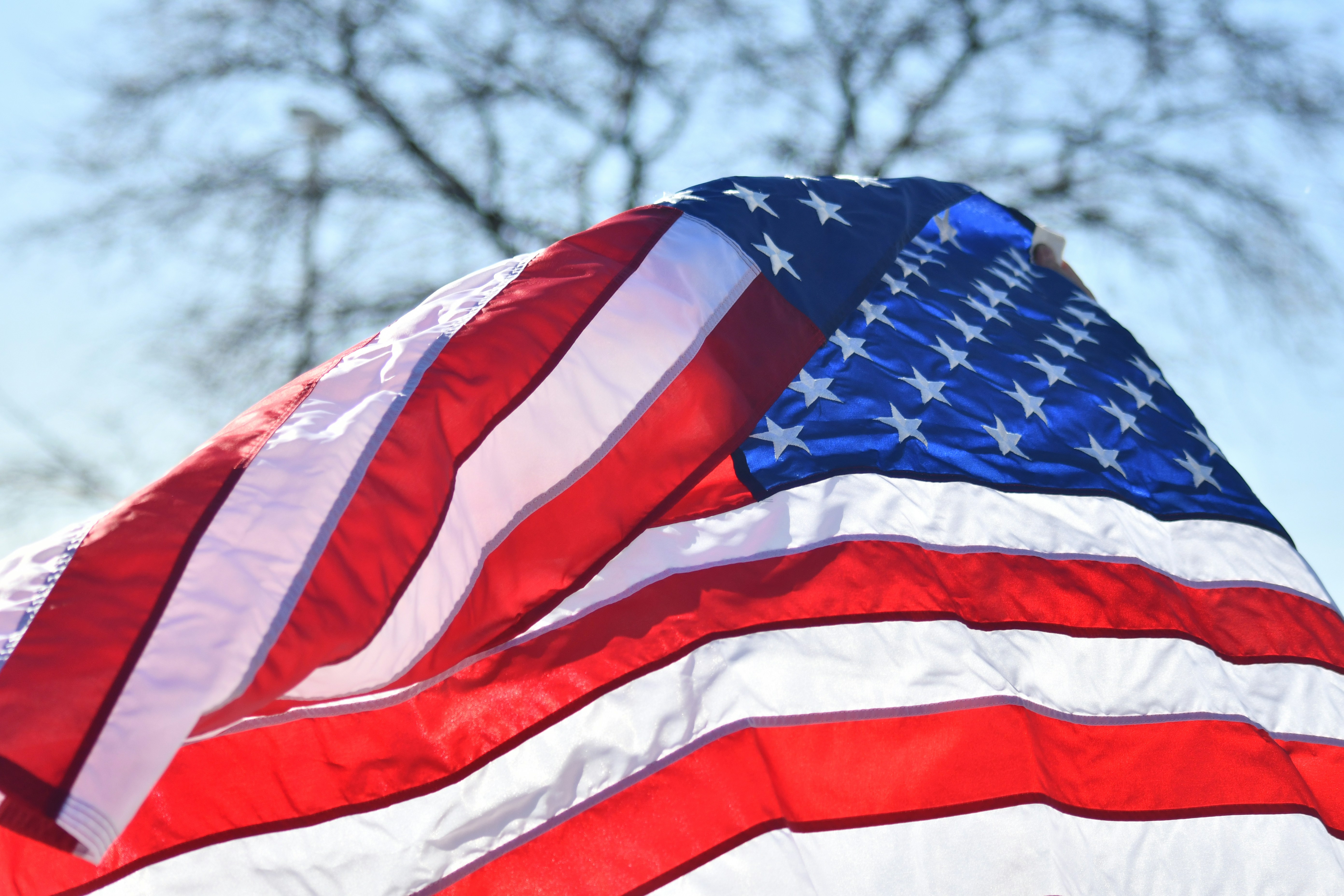 American flag waving against a bright sky.