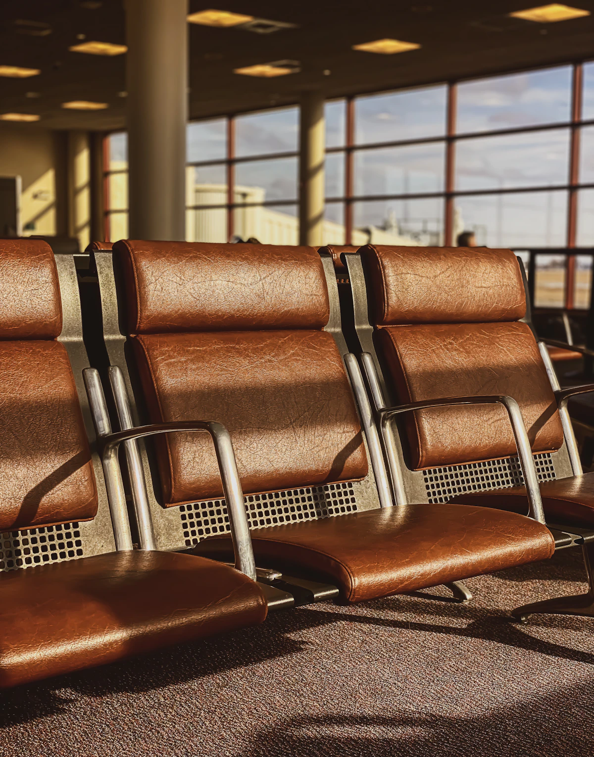 Rows of seating in an airport departure lounge with travellers waiting