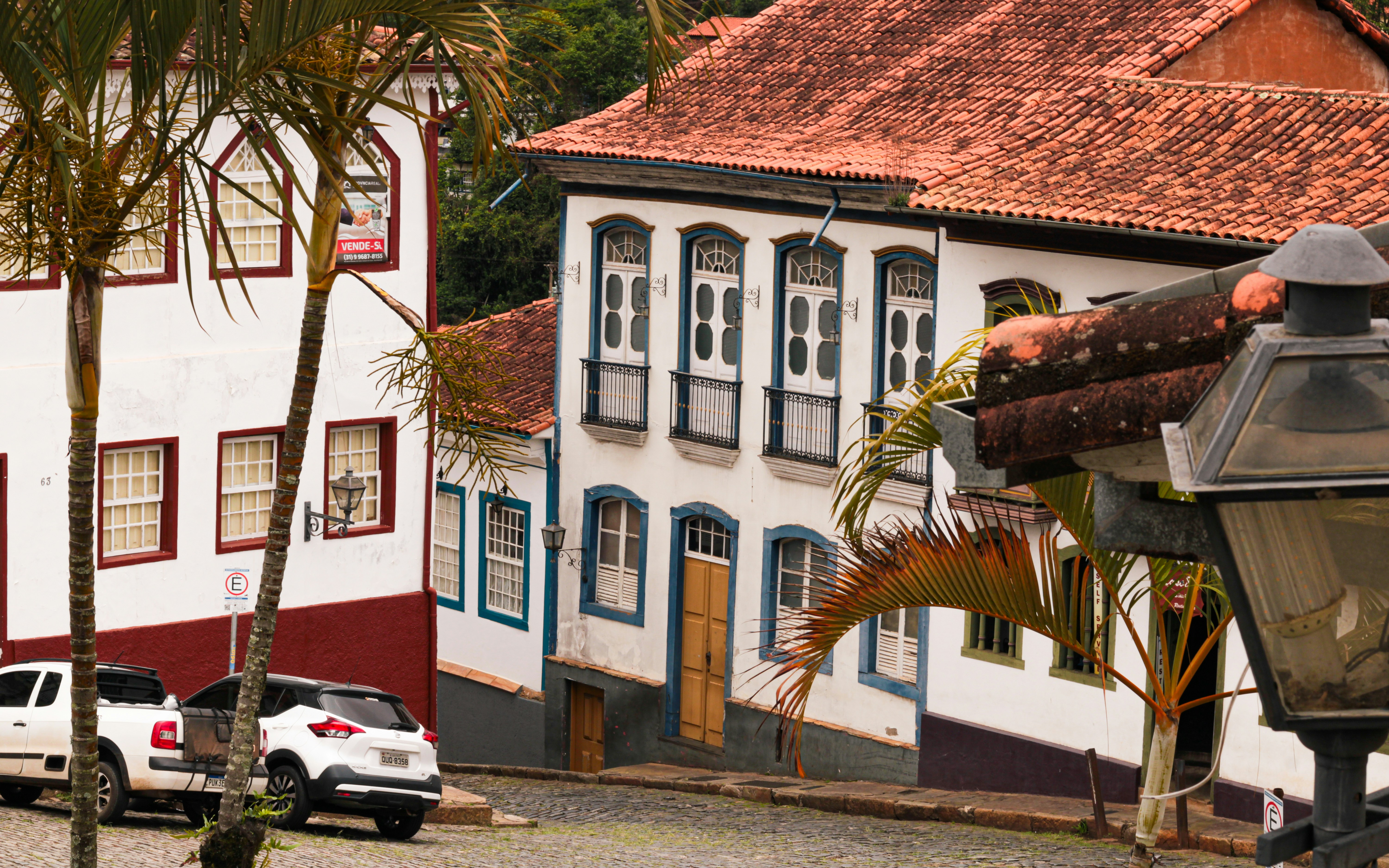 White colonial buildings with red roofs and palm trees.
