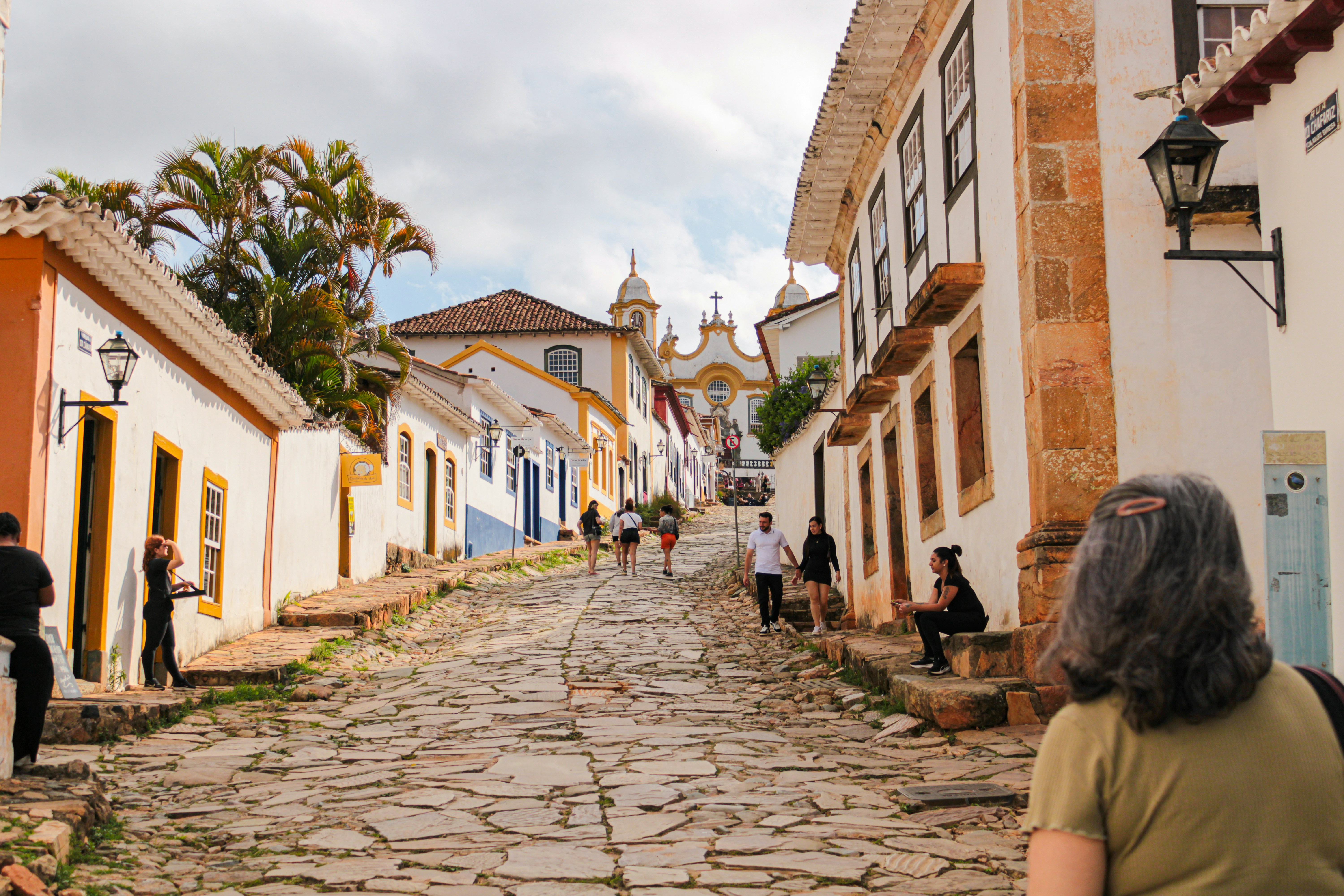 Cobblestone street in a historic town with buildings.