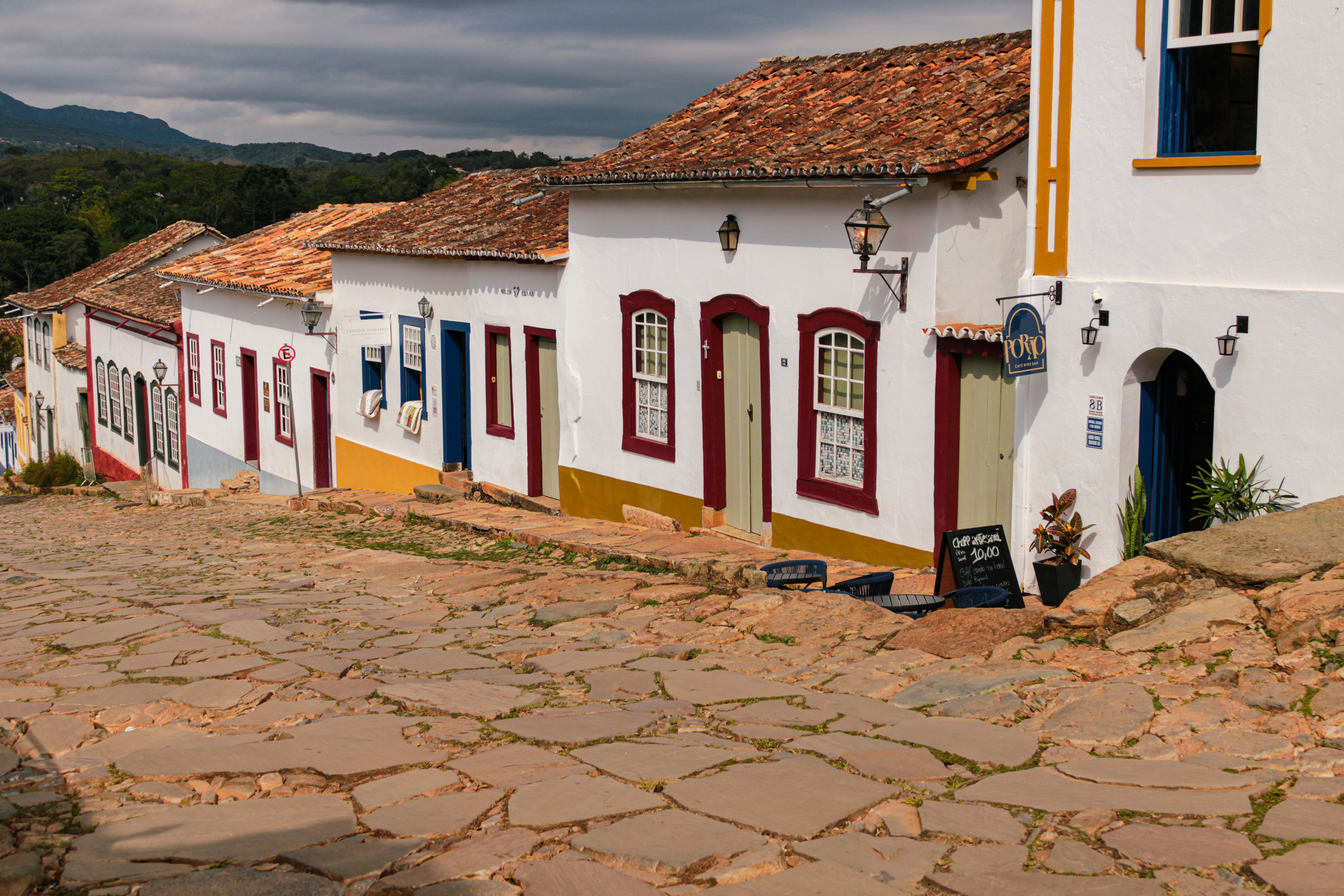 Cobblestone street lined with colorful colonial houses.