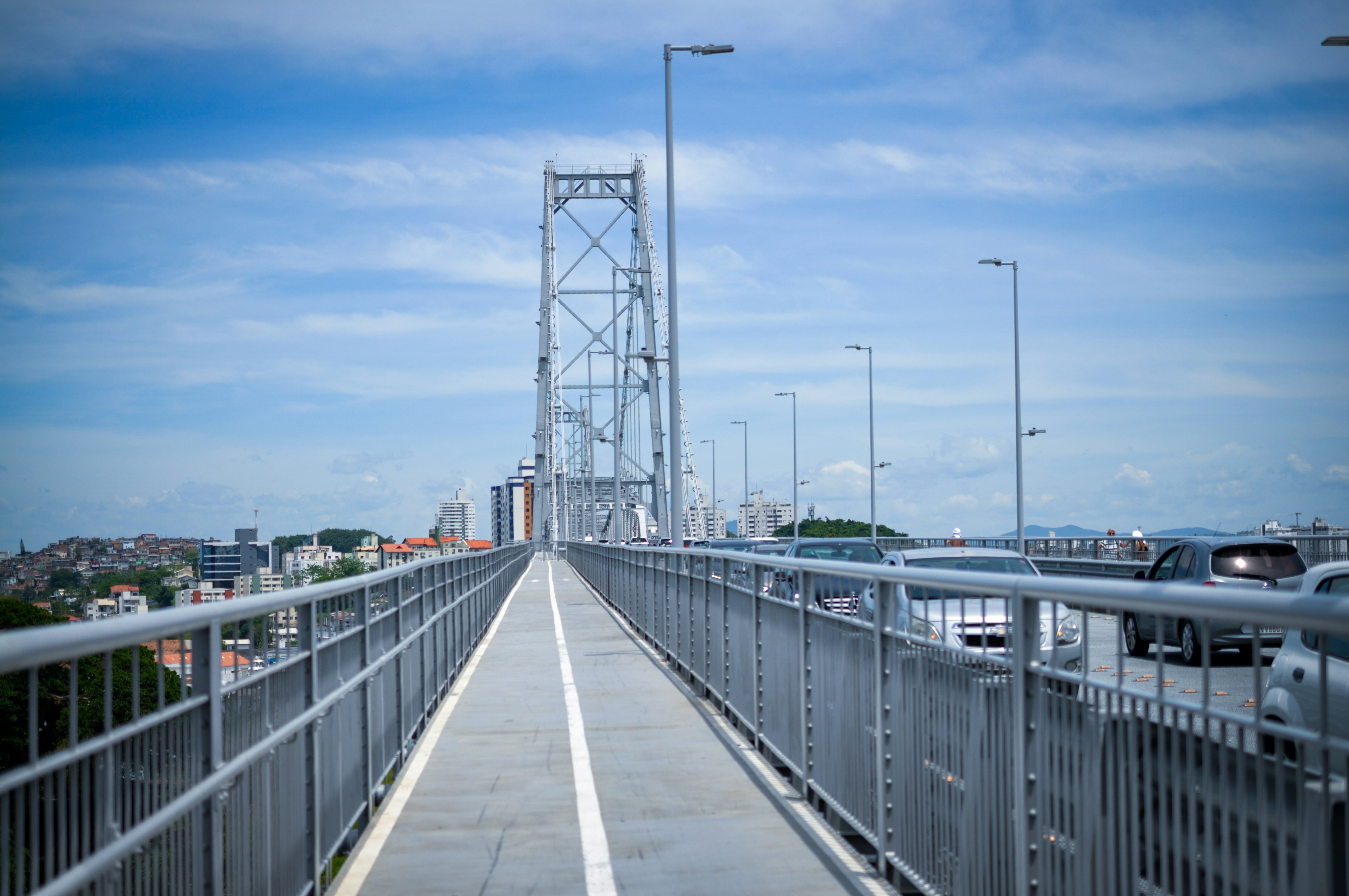 Cars driving on a suspension bridge under blue sky