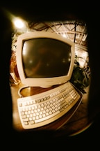Vintage computer monitor and keyboard on a desk.