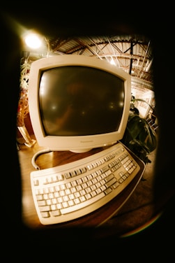 Vintage computer monitor and keyboard on a desk.