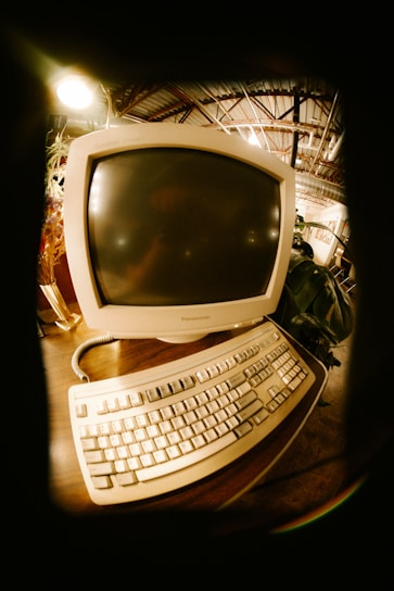 Vintage computer monitor and keyboard on a desk.