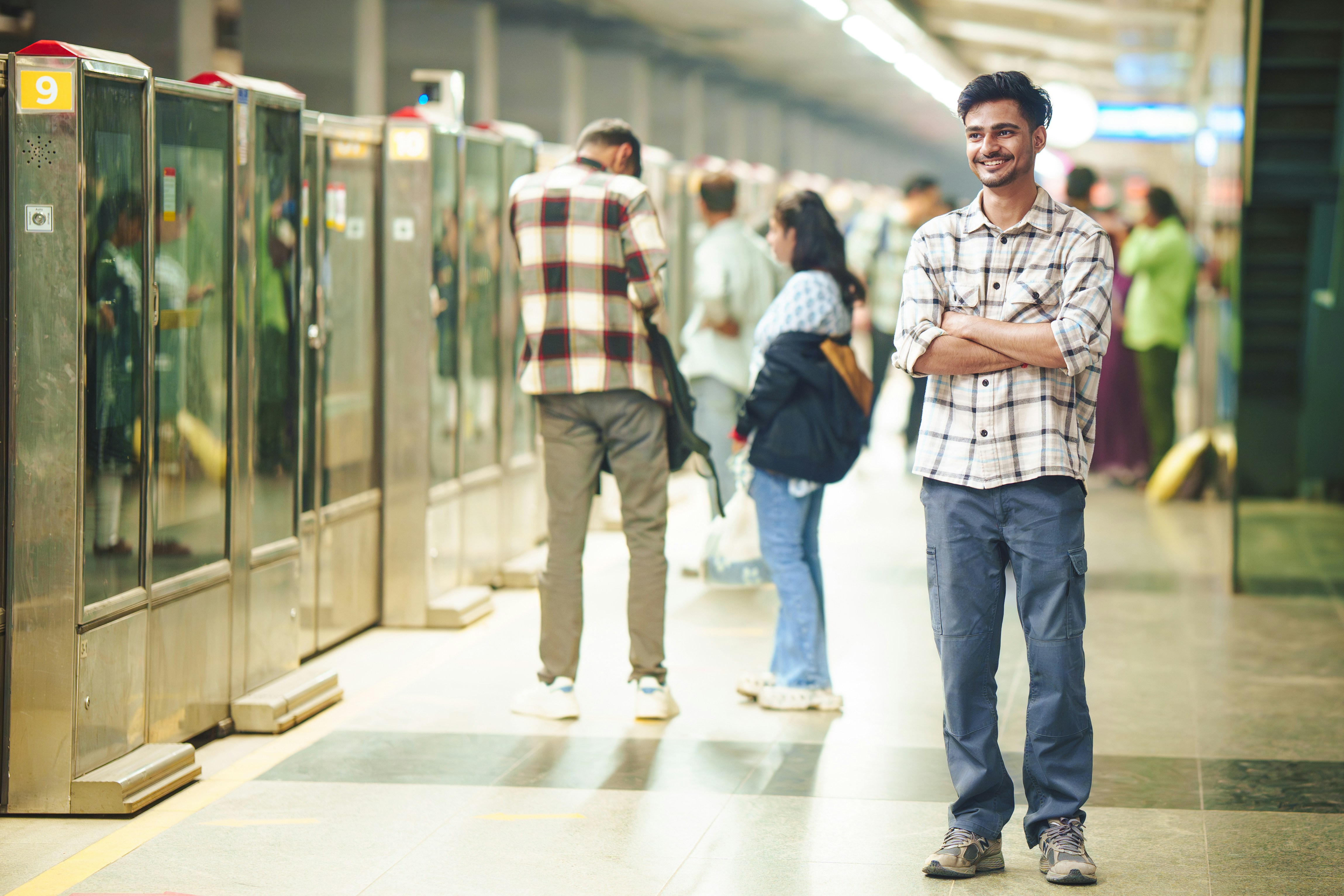 Man standing on a subway platform with people behind.