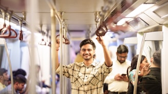 Man smiling while holding onto subway handrail