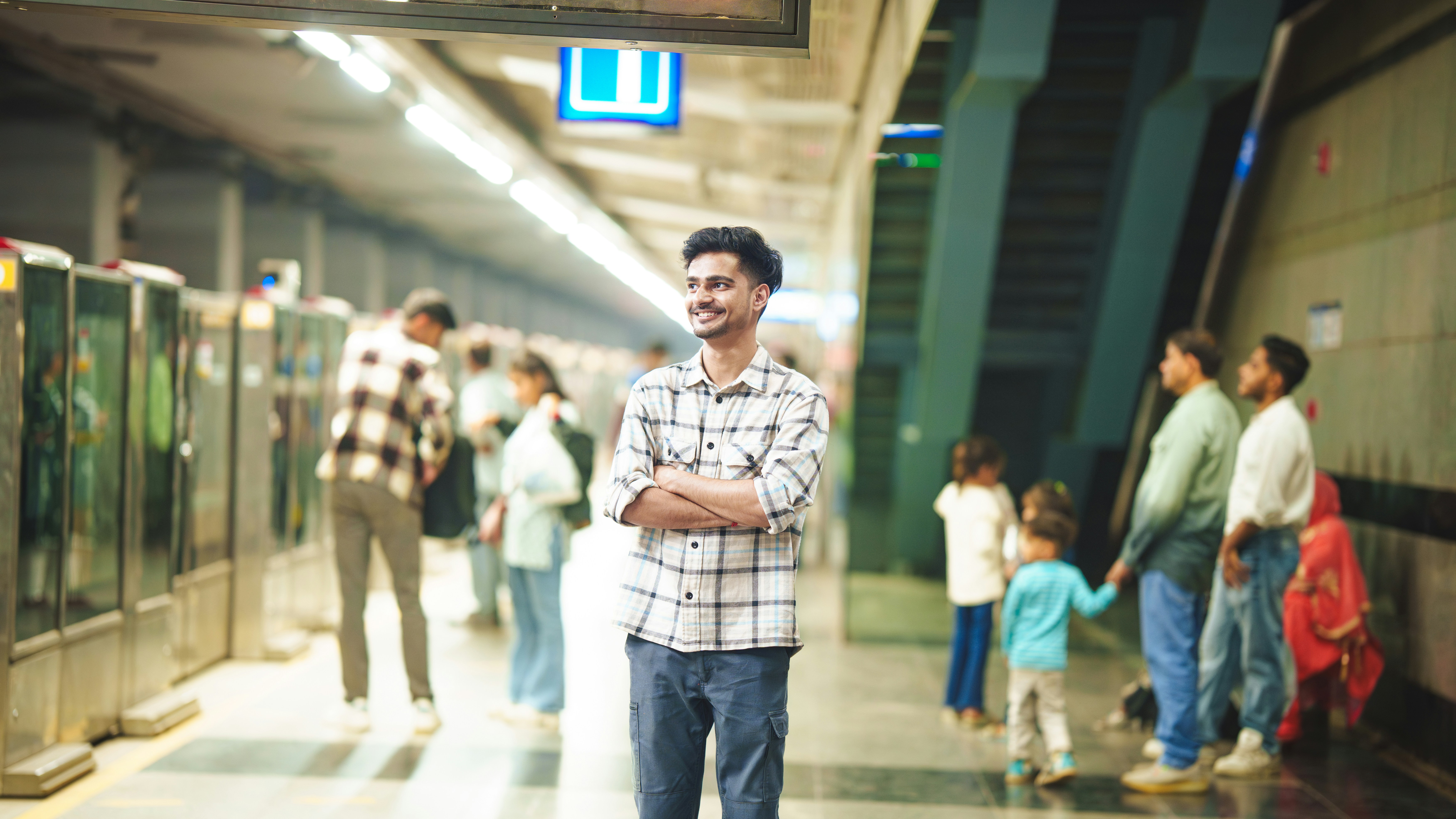 Man standing at a subway station with others
