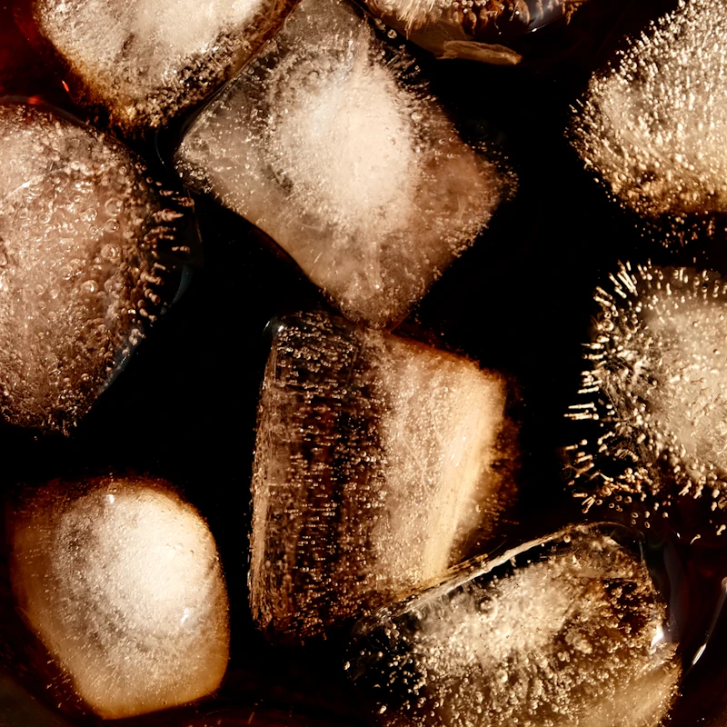 Dunkelbraunes Cola-Slush-Eis in einem durchsichtigen Becher