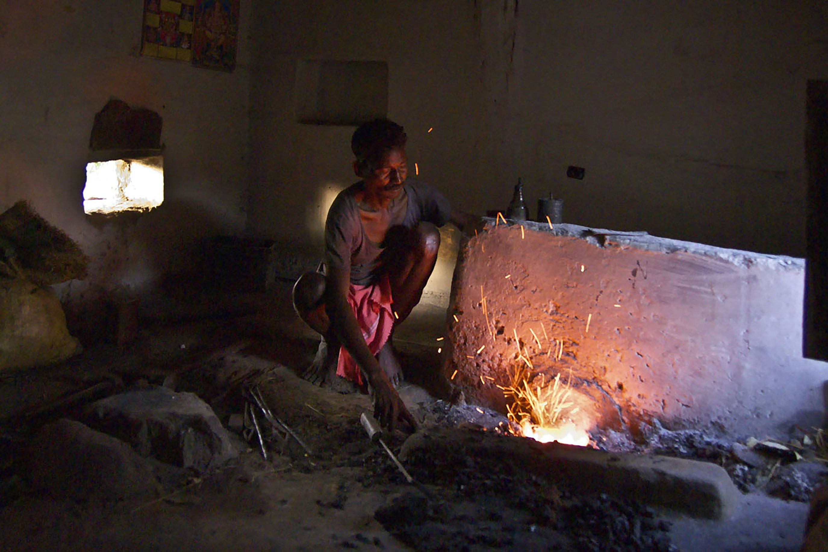 Person working at a forge with sparks flying