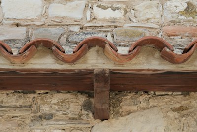 Old stone wall meeting terracotta roof tiles