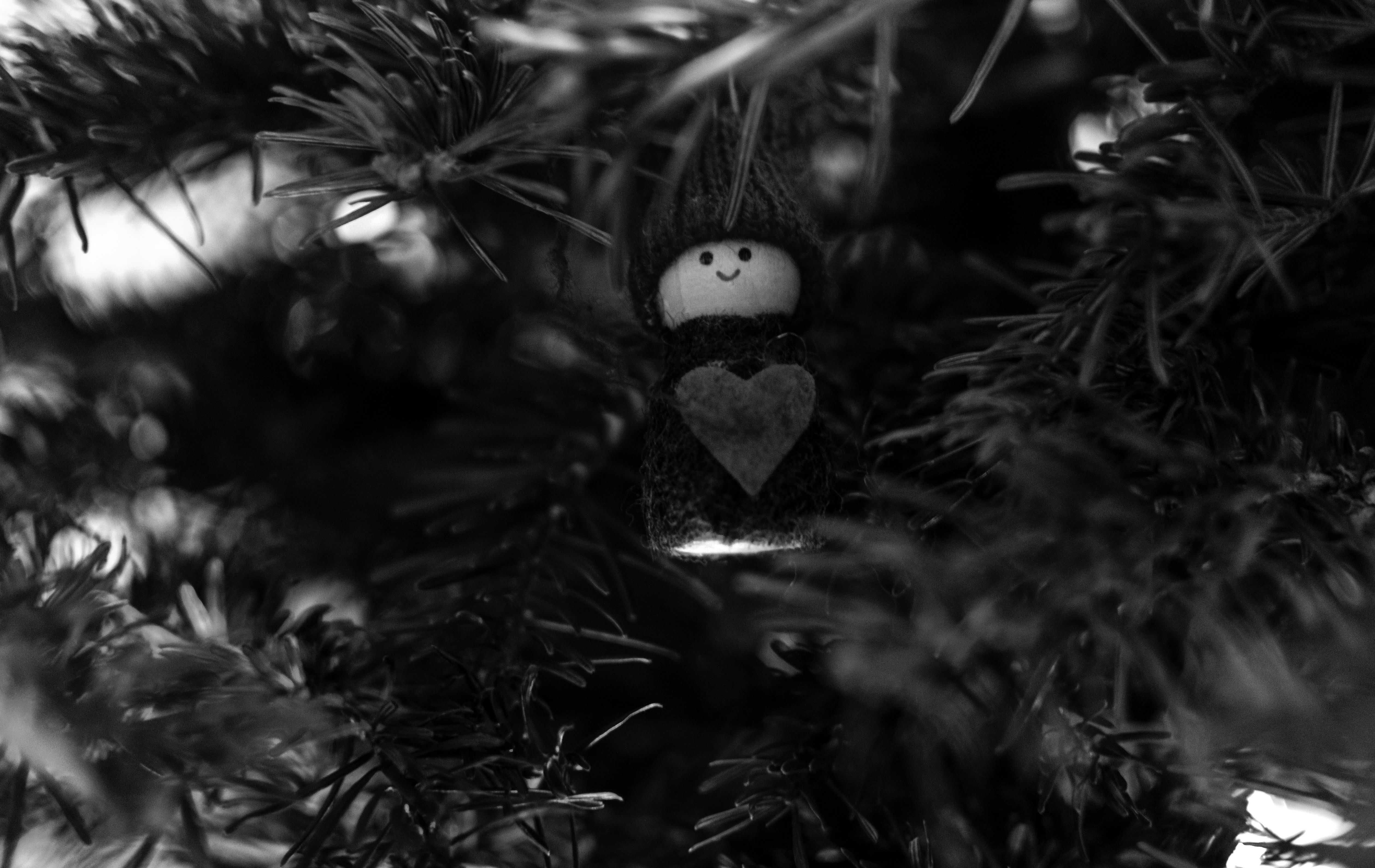 A small angel ornament nestled in pine branches.