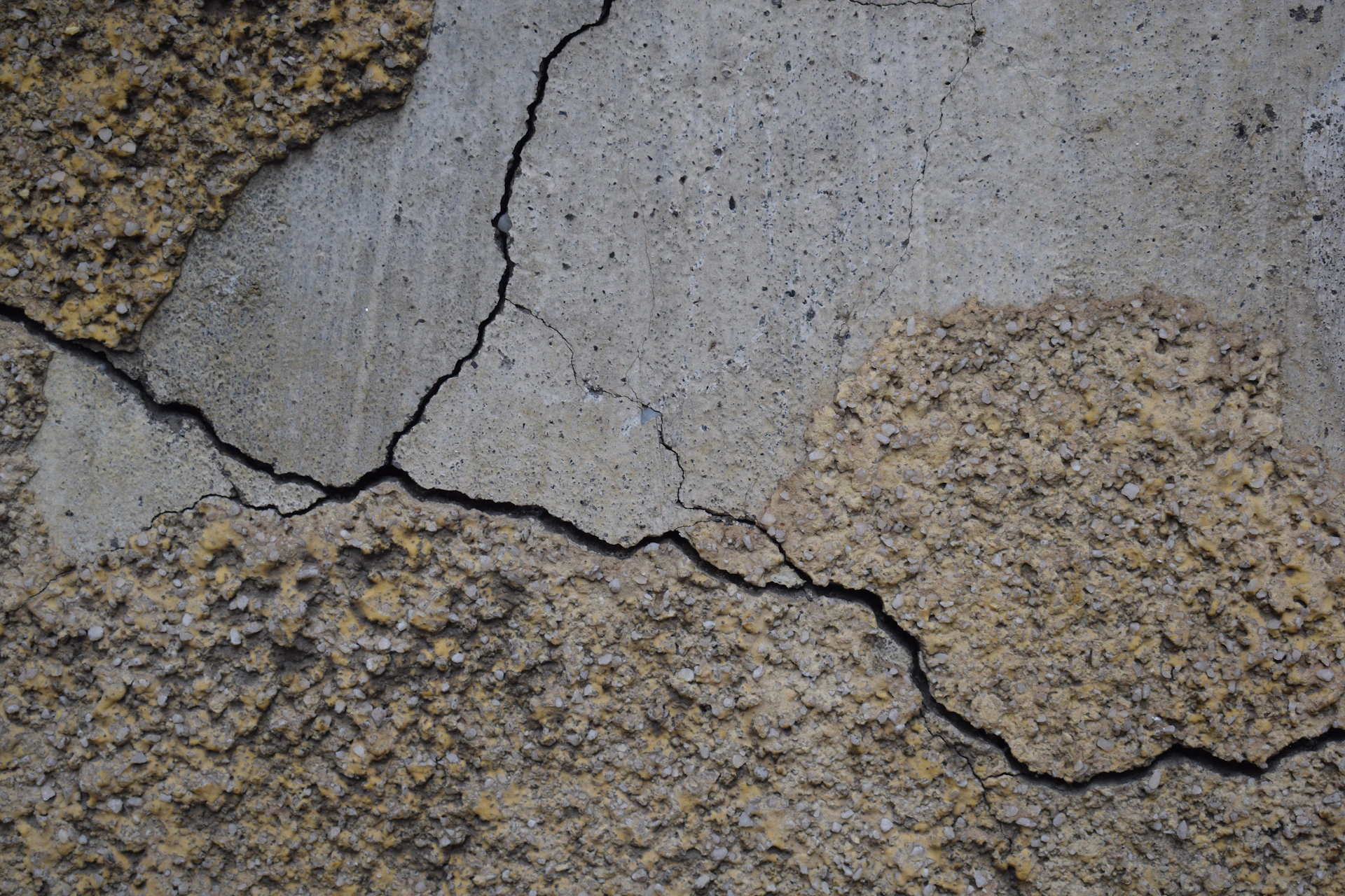Cracked concrete wall with textured patches