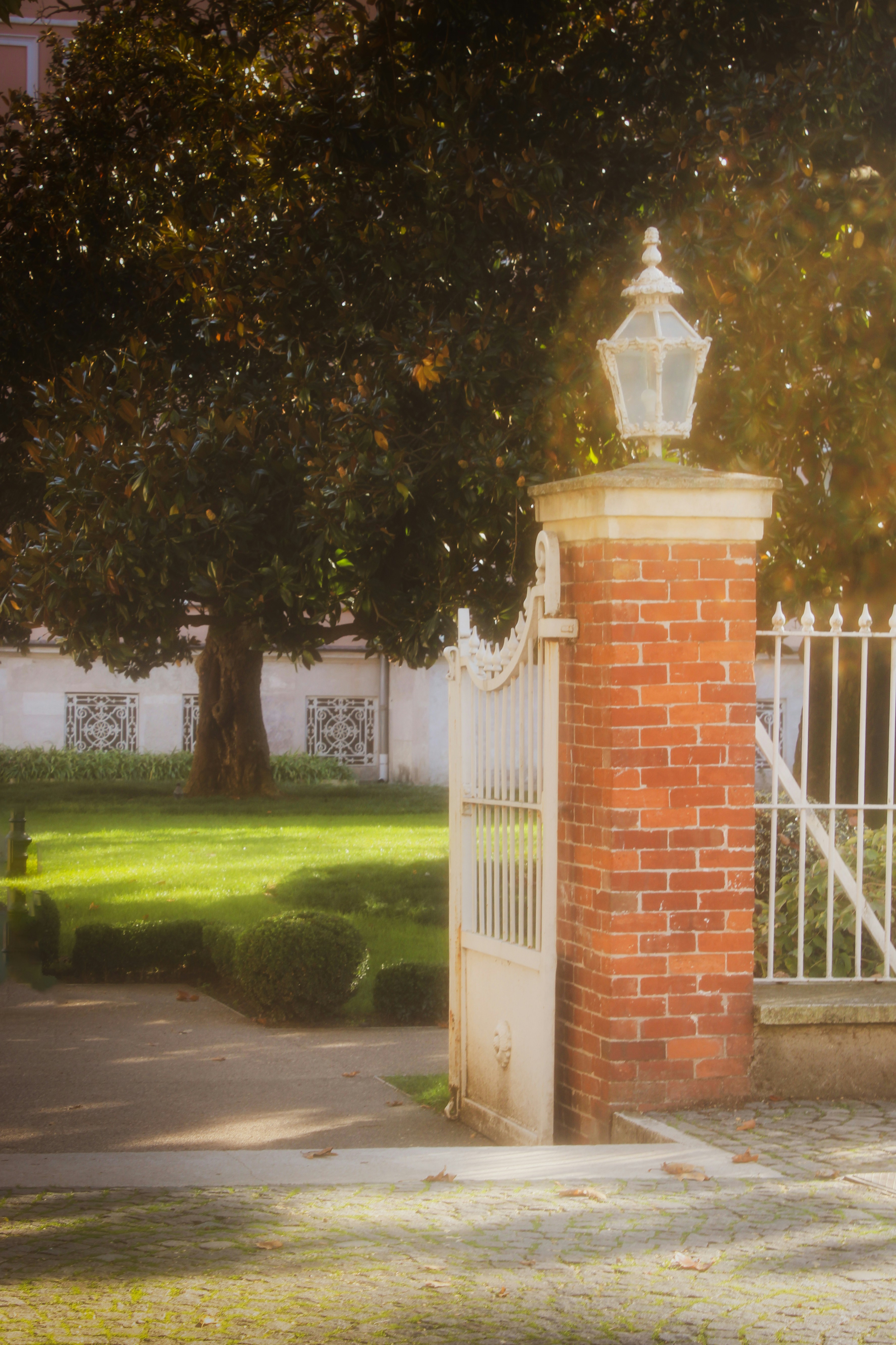 Puerta ornamentada con pilar de ladrillo y lámpara