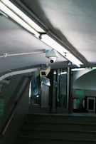 Security cameras mounted under fluorescent lights.