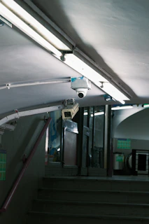 Security cameras mounted under fluorescent lights.