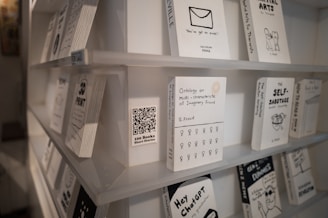 Books with minimalist black and white covers on shelves.