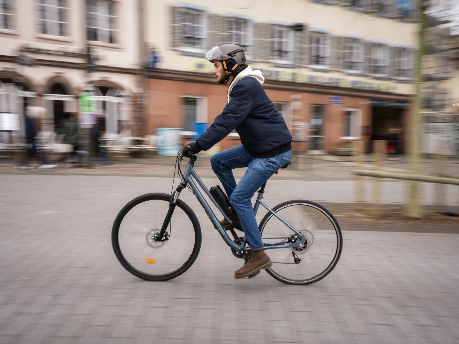 Helmeted cyclist riding through a city street