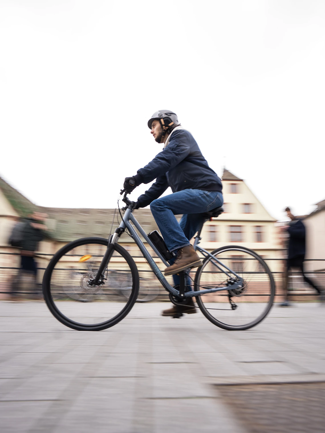 Helmeted cyclist riding through an urban setting