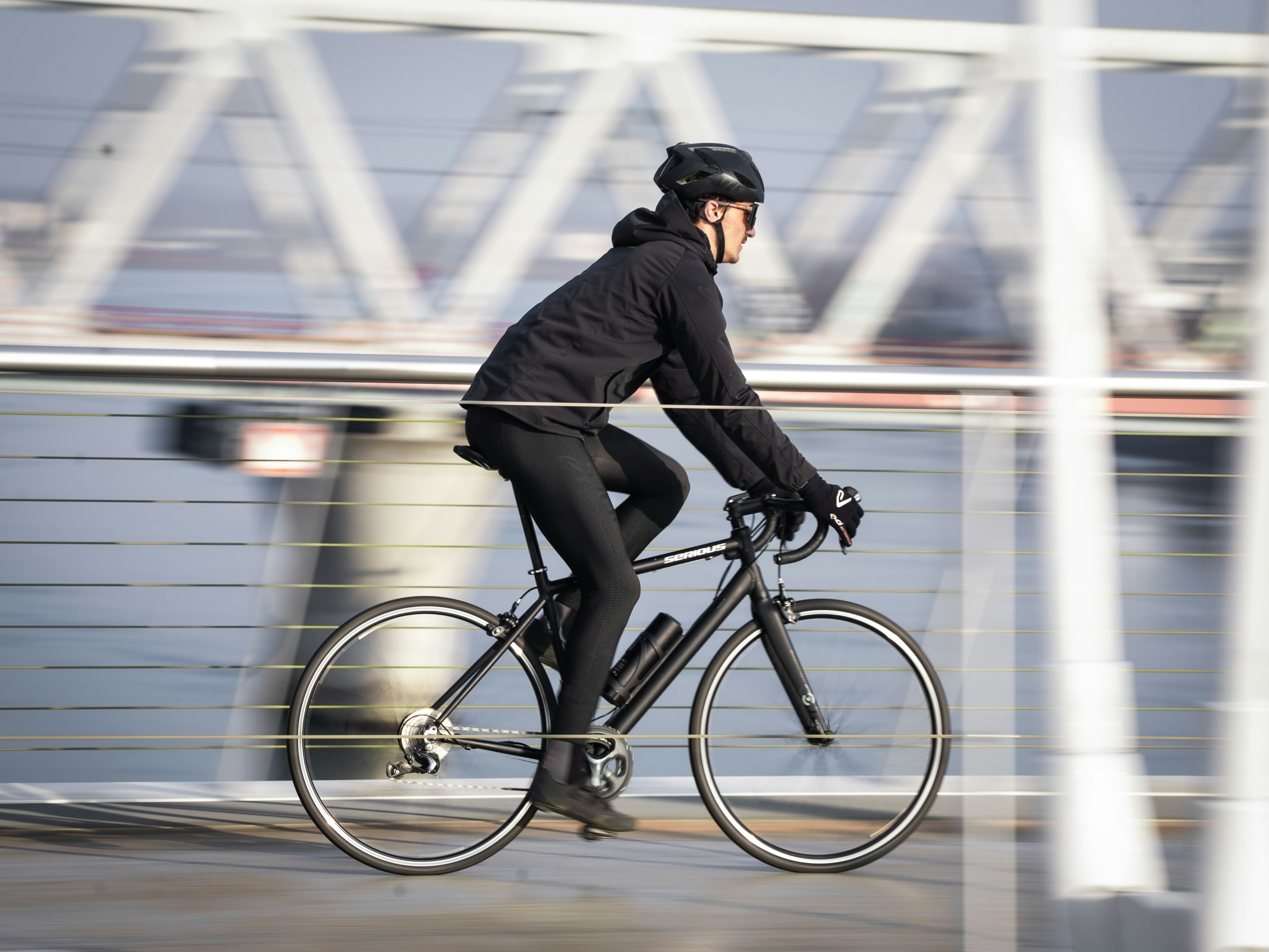 Person cycling on a bridge with motion blur