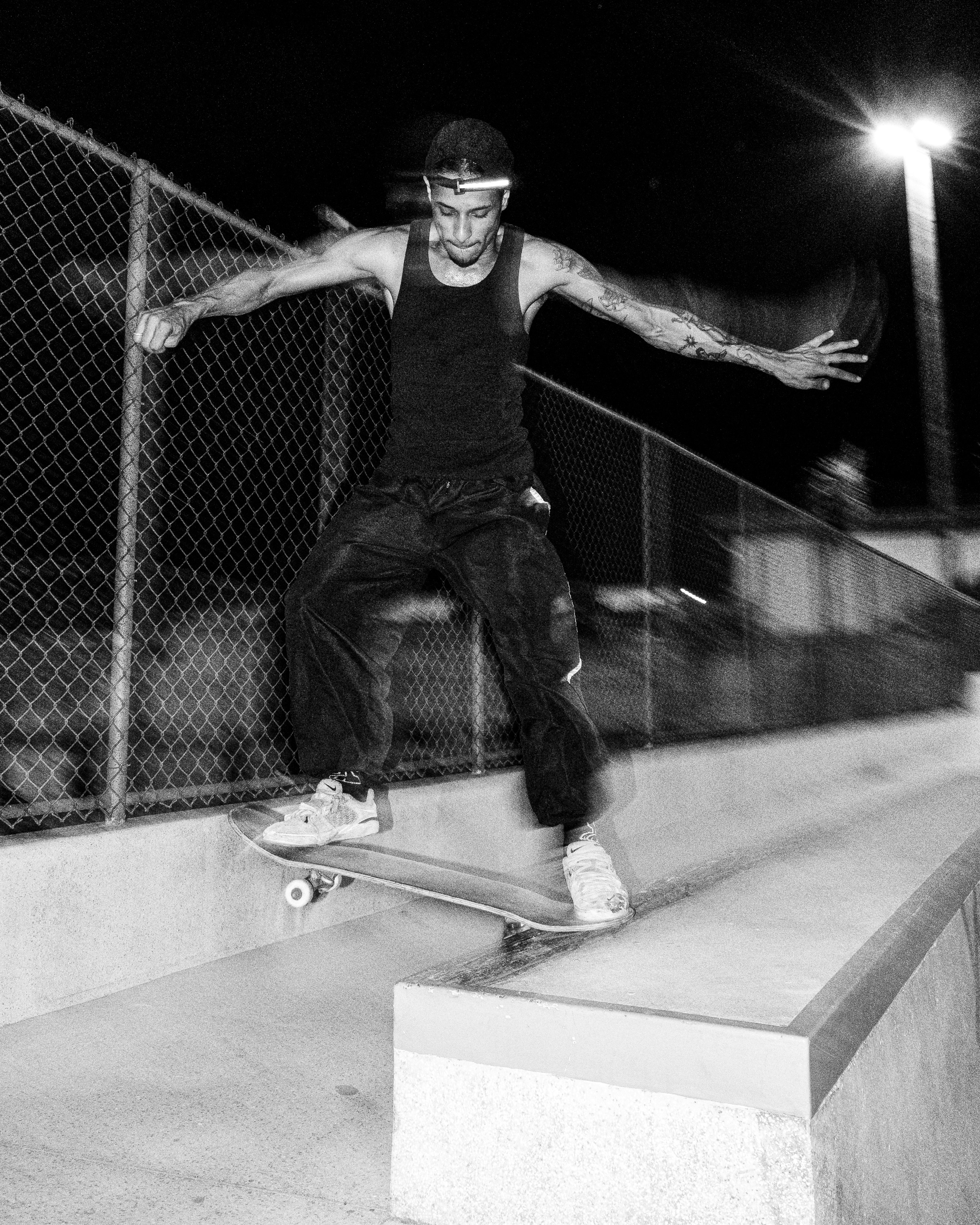Skateboarder grinding on a ramp at night