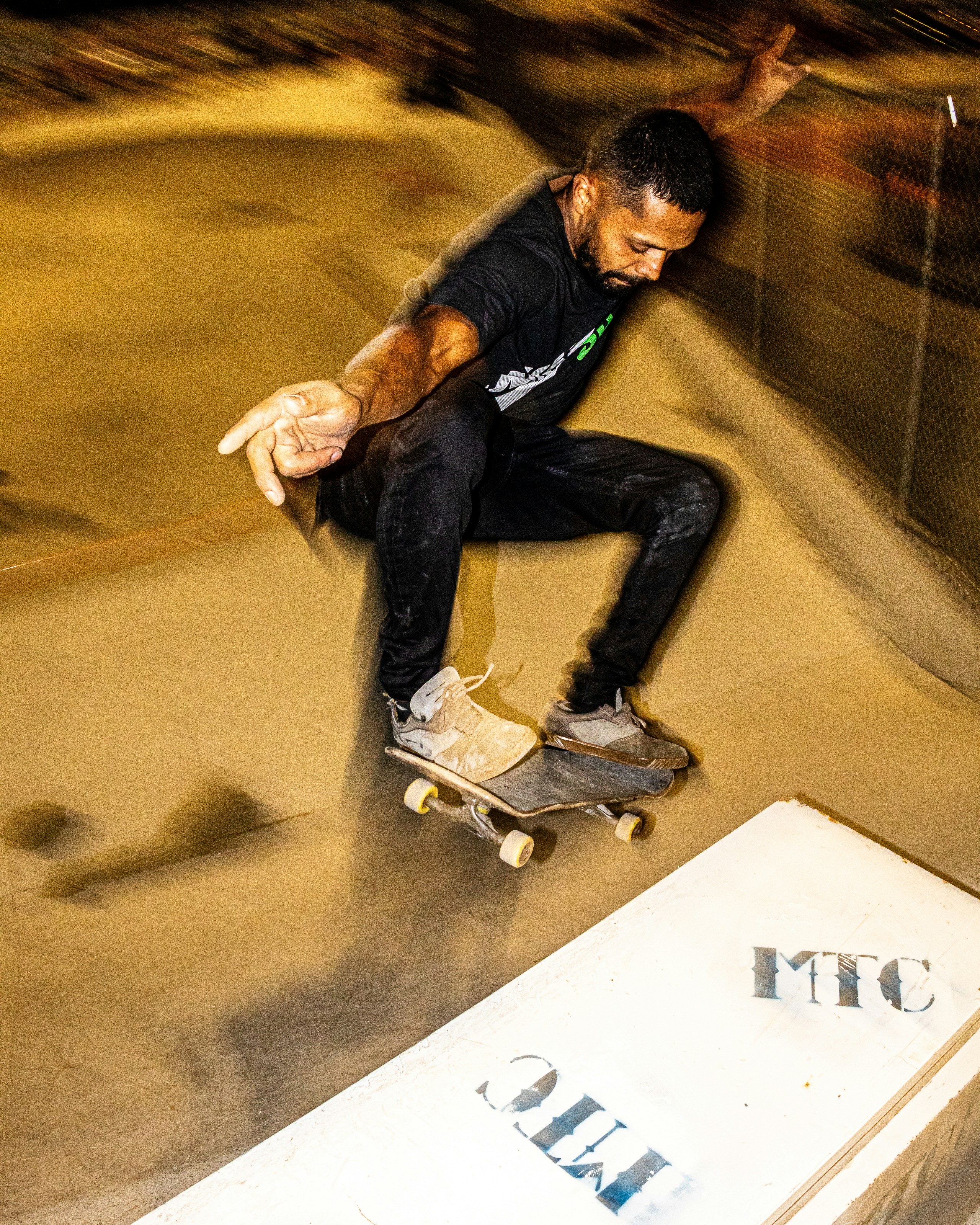 Man performs trick on skateboard in skatepark