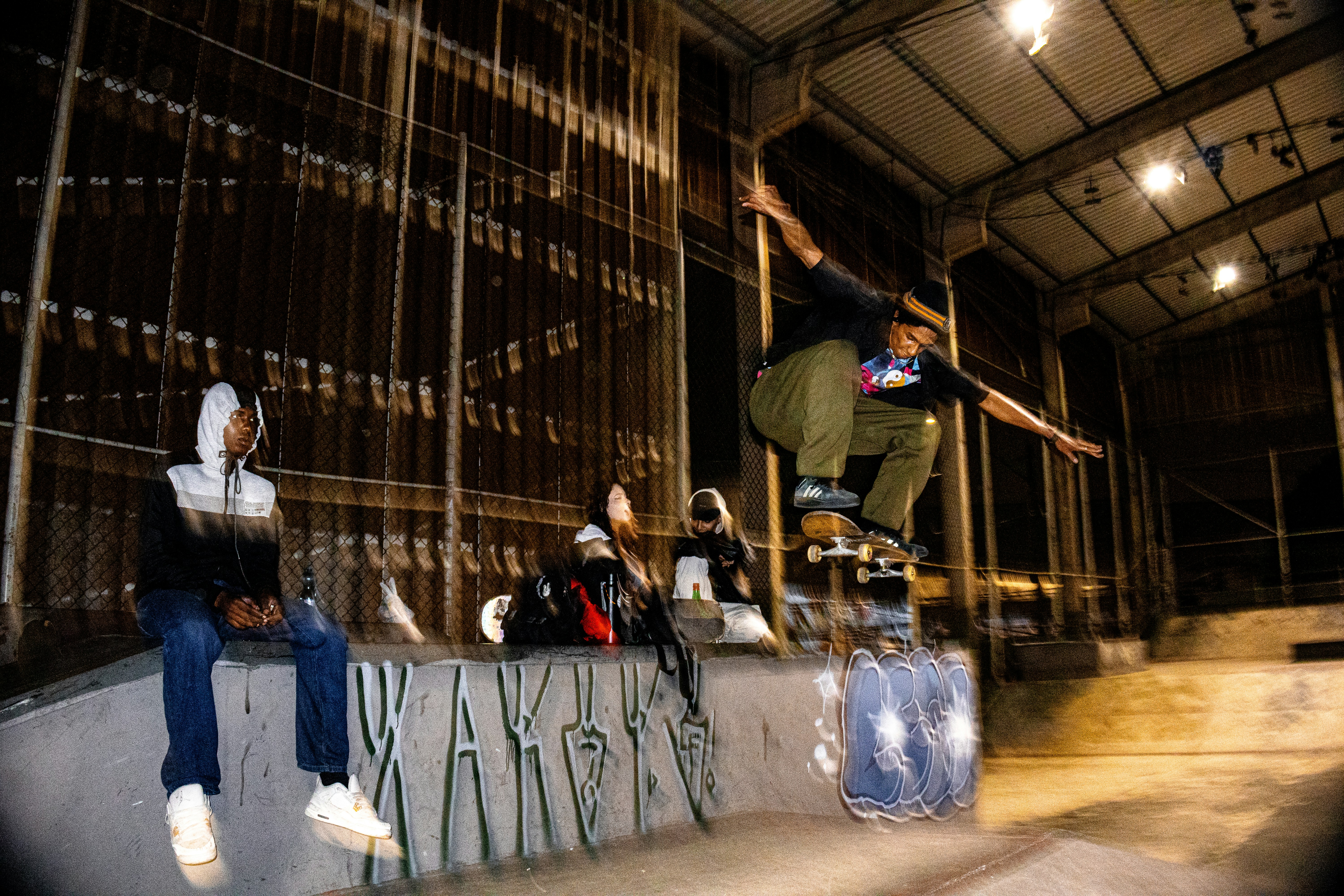 Skateboarder performing a trick in an indoor skatepark.