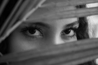 Woman peeking through blinds