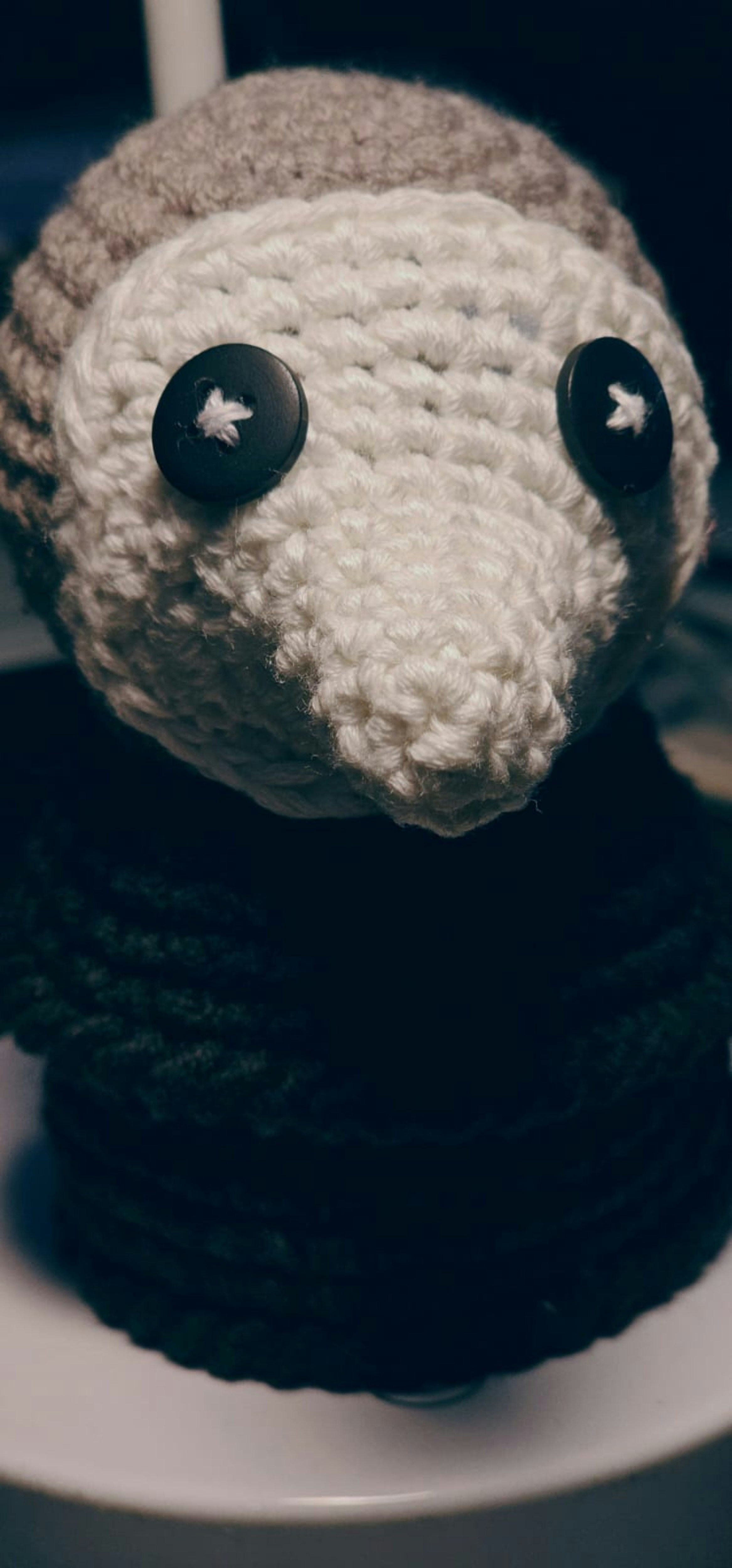 Crocheted doll with button eyes and a hat