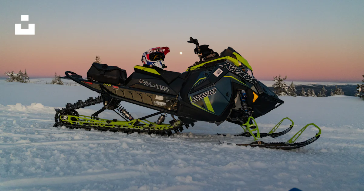 Snowmobile parked in a snowy landscape at dusk. photo – Free Travel ...