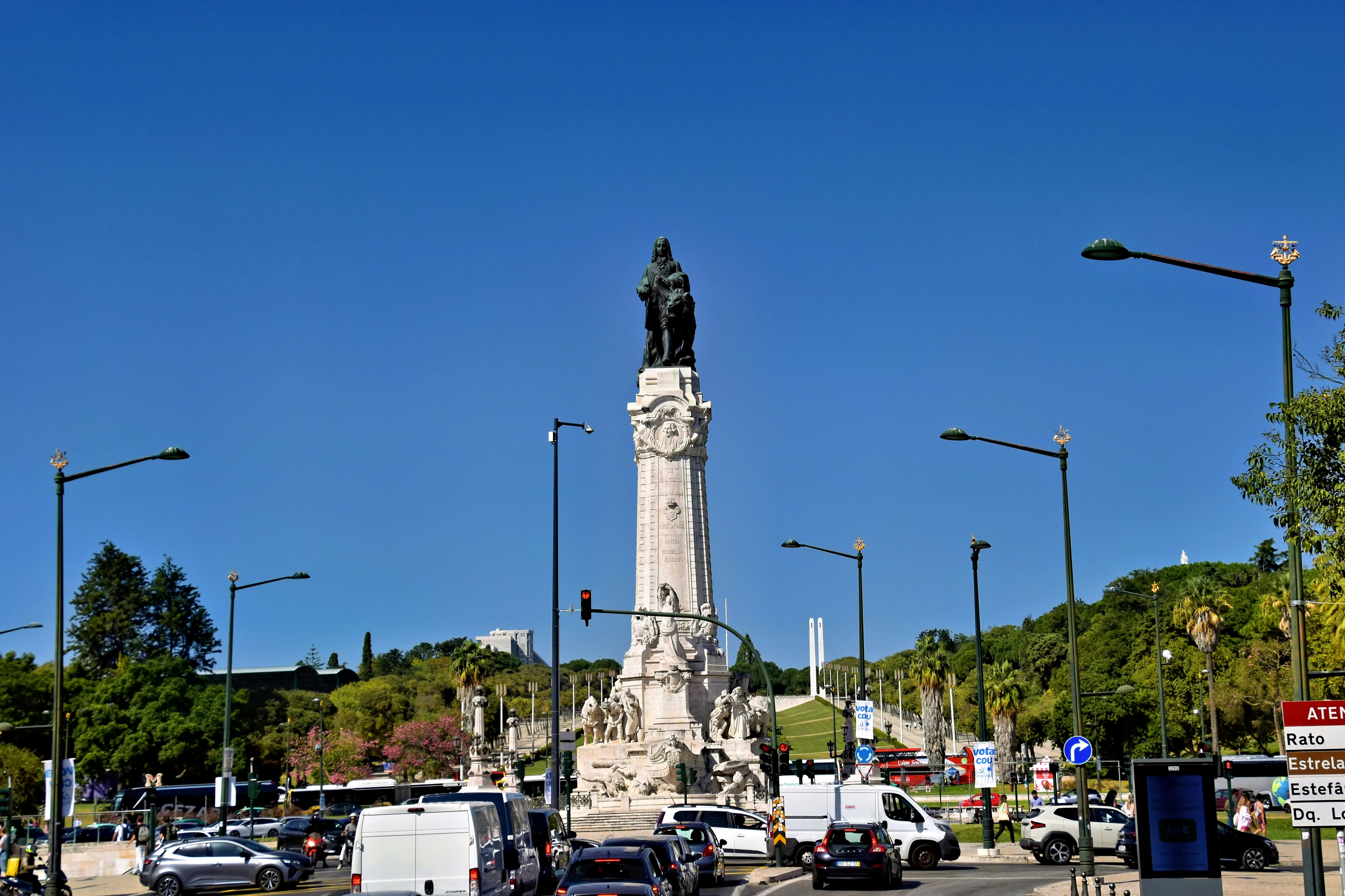 Monument in a busy city square with cars.