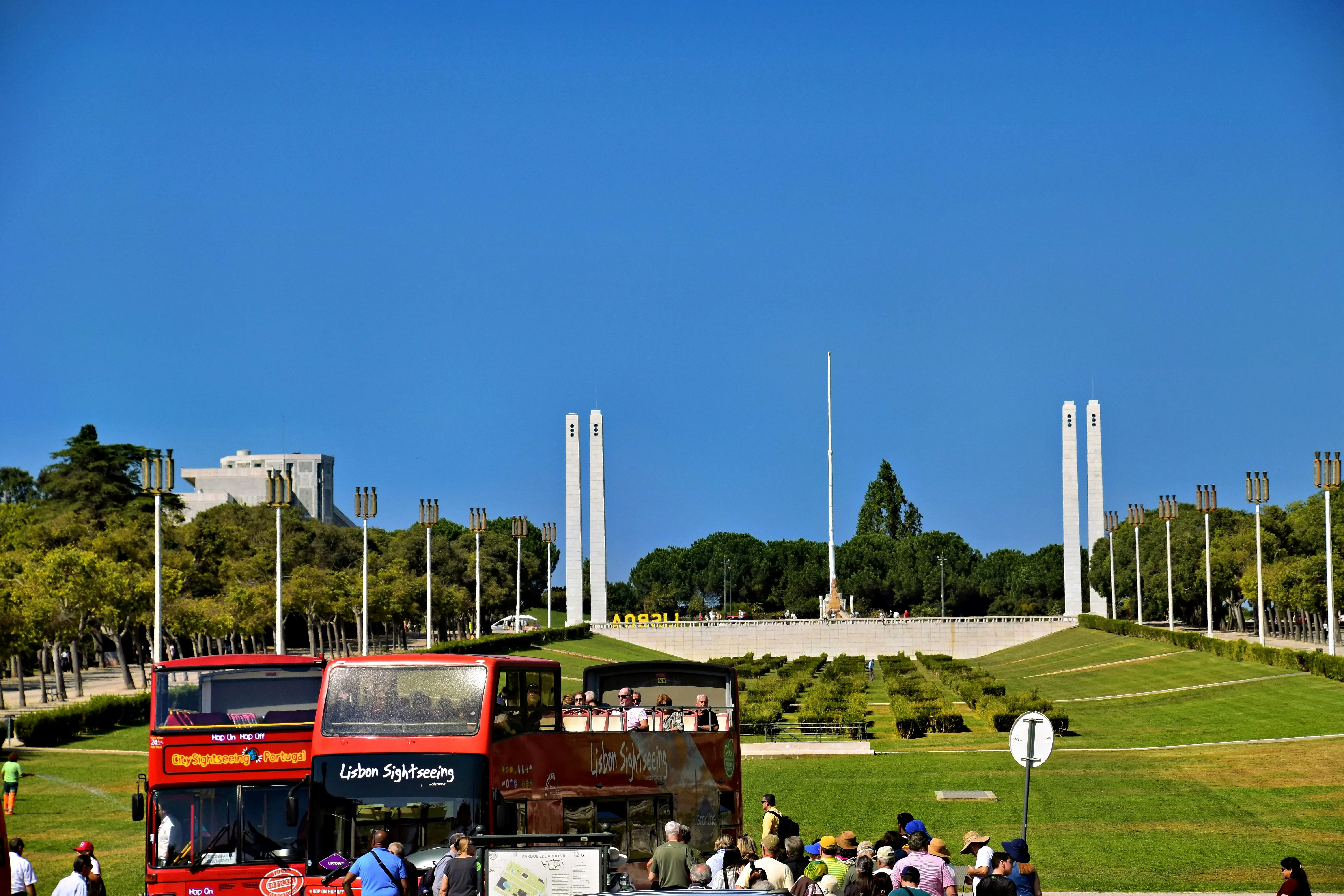 Double-decker bus in front of monument with modern monument