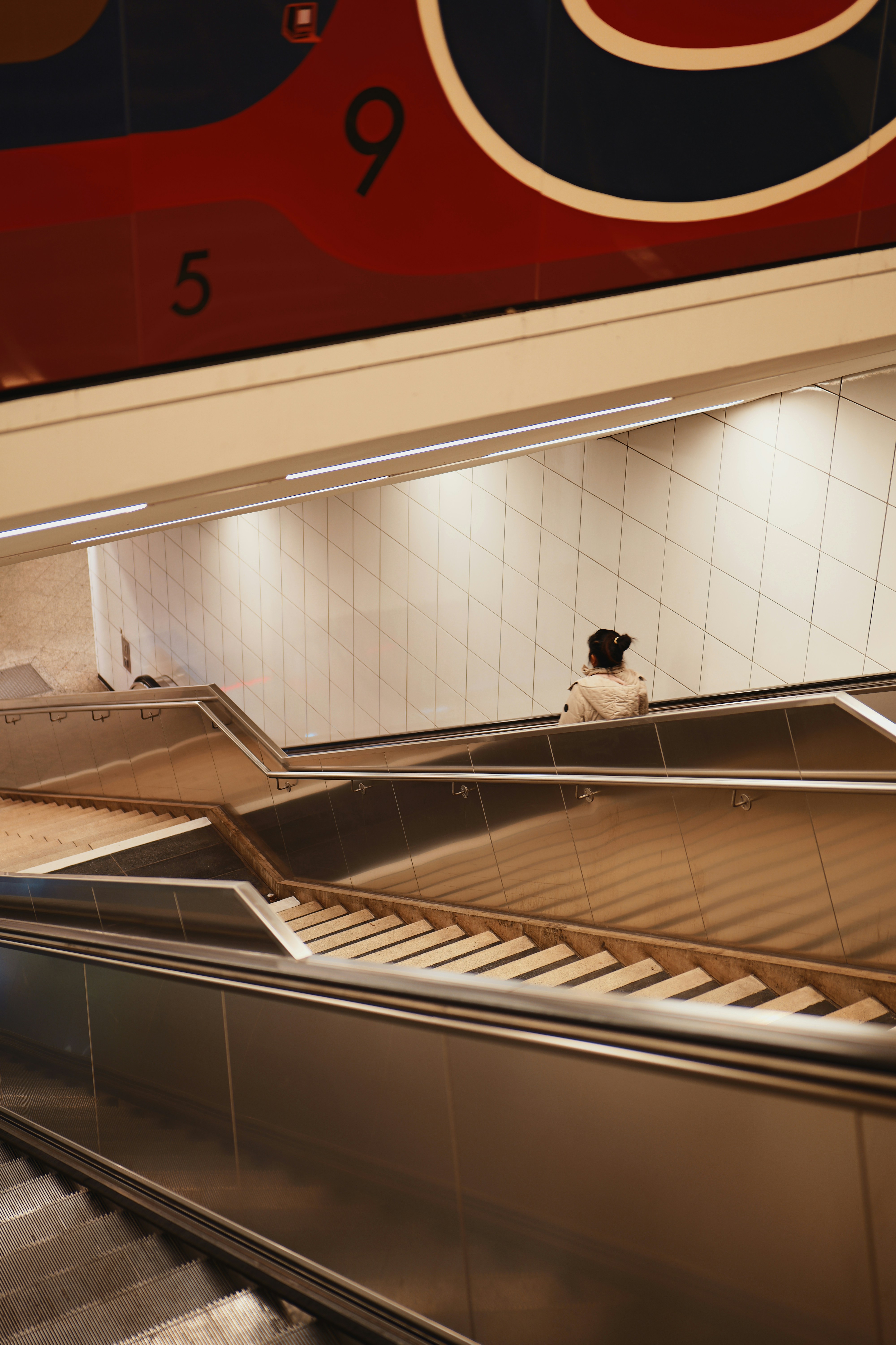 Woman on escalator in modern subway station - woman-on-escalator-in-modern-subway-station-bShP3V31M54