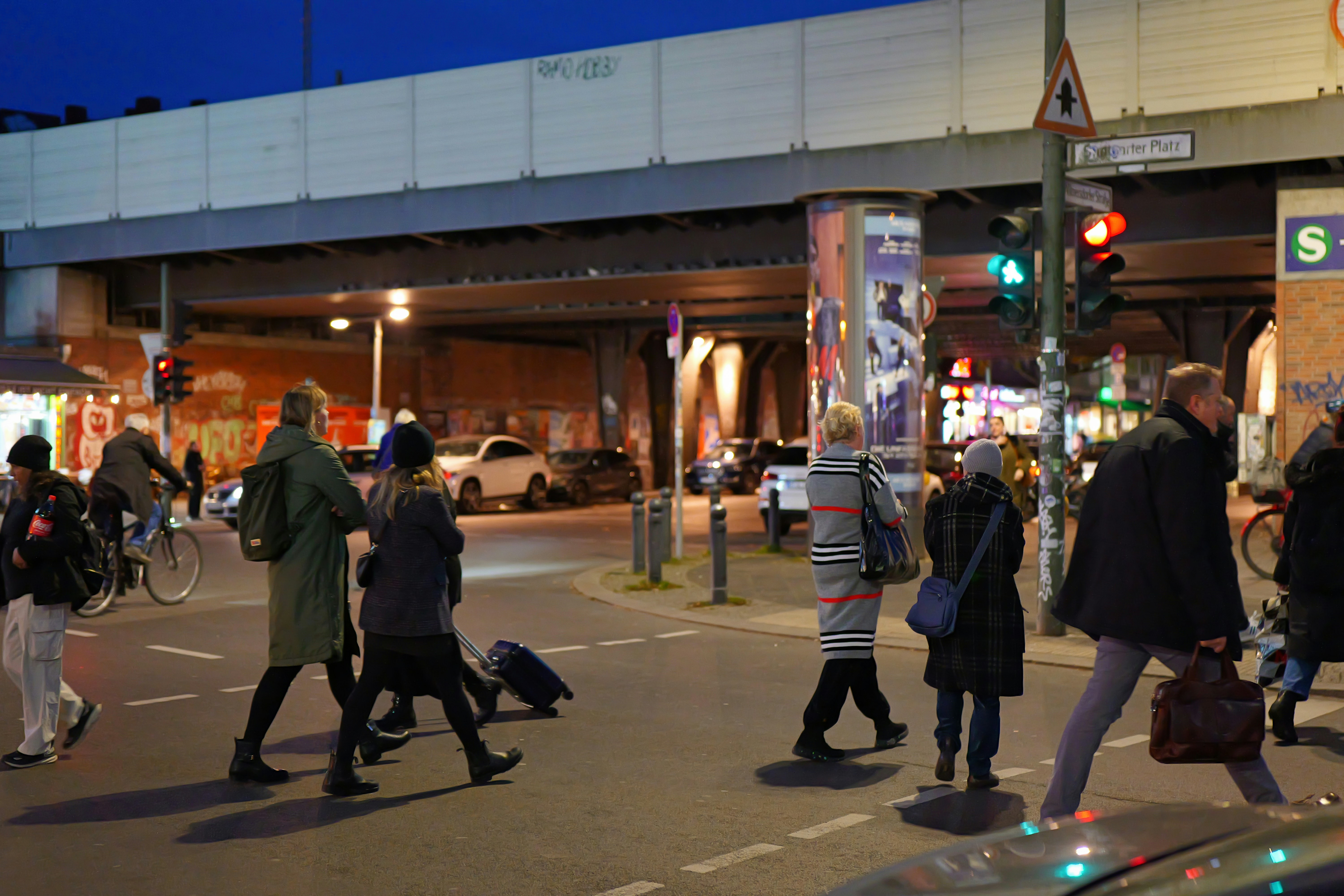 People crossing street at dusk under elevated train tracks - people-crossing-street-at-dusk-under-elevated-train-tracks-oa1xsLiUQQU