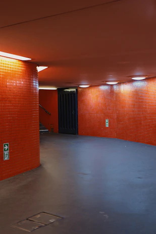 Orange tiled hallway with illuminated ceiling lights.